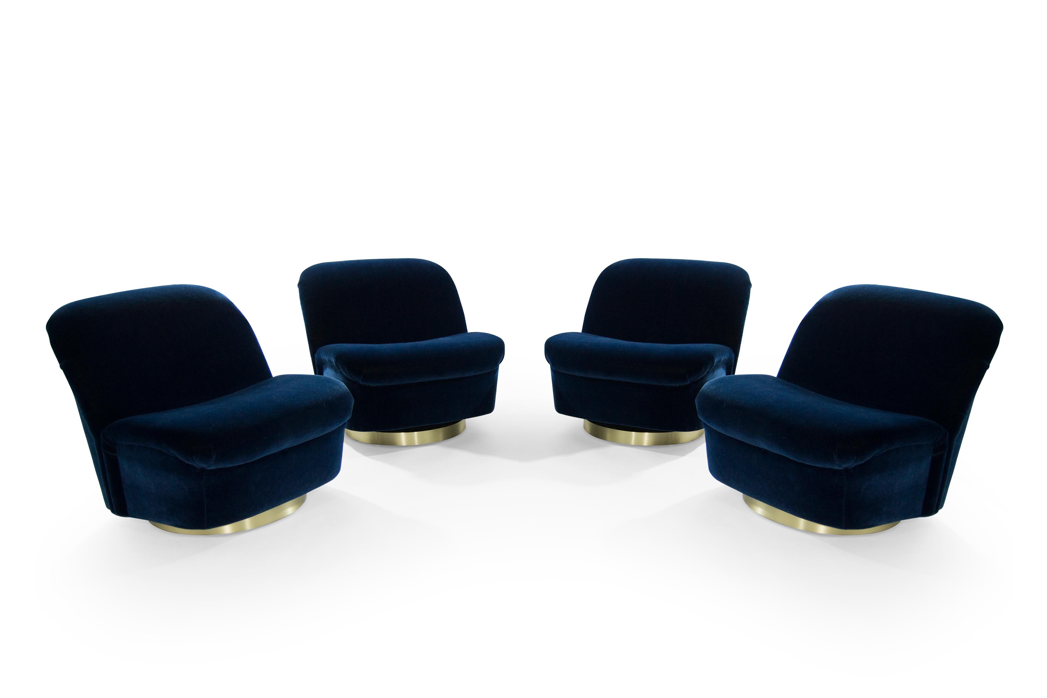 Set of four large scale swivel tilt lounge chairs by Directional. Newly upholstered in navy blue mohair, bases newly fitted with brushed brass in satin finish. Design attributed to Vladimir Kagan. Priced as a set of four. Extremely comfortable.