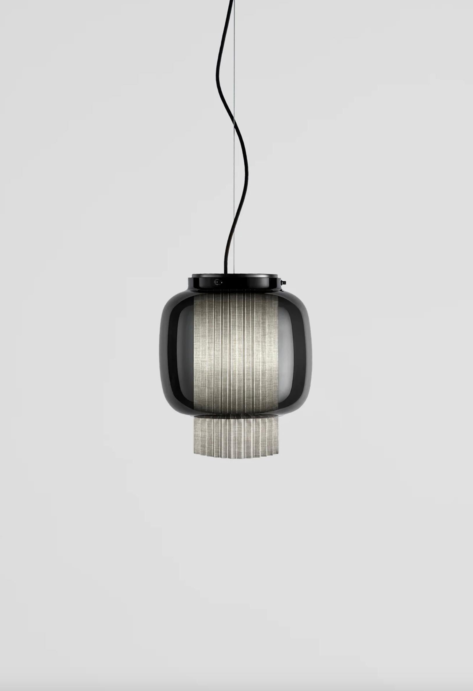 Sebastian Herkner Manila T Pe Beige Lampada a sospensione in tessuto per Parachilna 

Una combinazione incredibilmente elegante di vetro soffiato artigianale e diffusore in tessuto plissé. Il suo nome deriva dallo spagnolo 