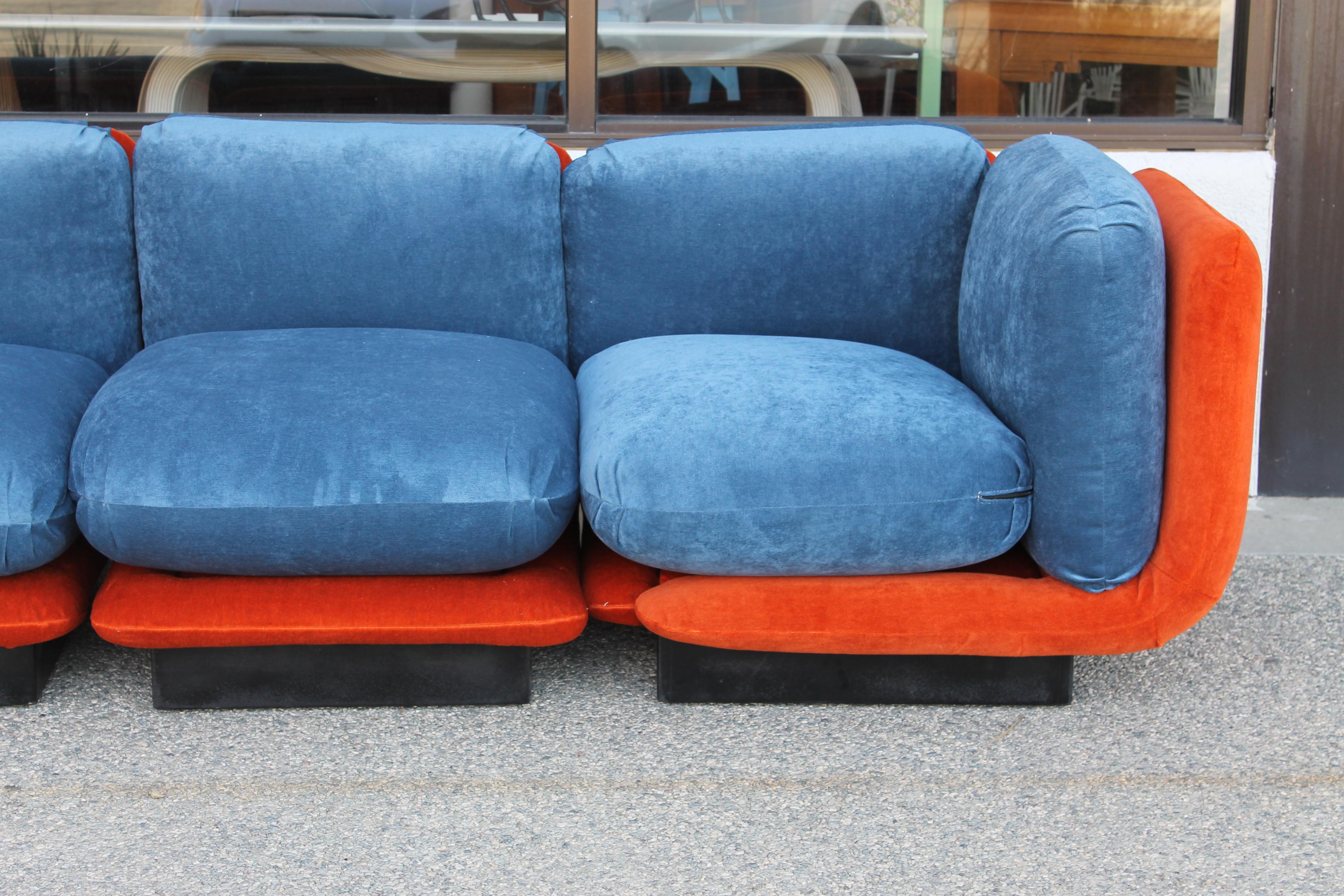 Sectional sofa consisting of 4 interchangeable pieces on wood bases. We had it upholstered in an identical orange and blue mohair fabric. Labels date it from 1980 and made at Hayes Furniture Manufacturers, Oakland, California. Sofa measures 120