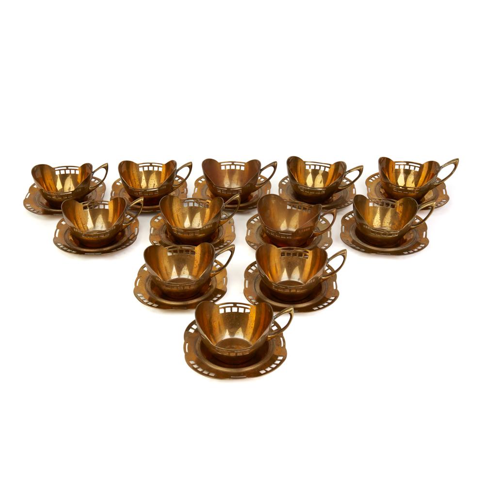 A stylish set twelve Austrian secessionist brass cup holders and matching saucers designed by Hans Ofner, a student of Josef Hoffmann (1870-1956) and certainly reflecting his style and design. The cups are slightly boat shaped with openwork