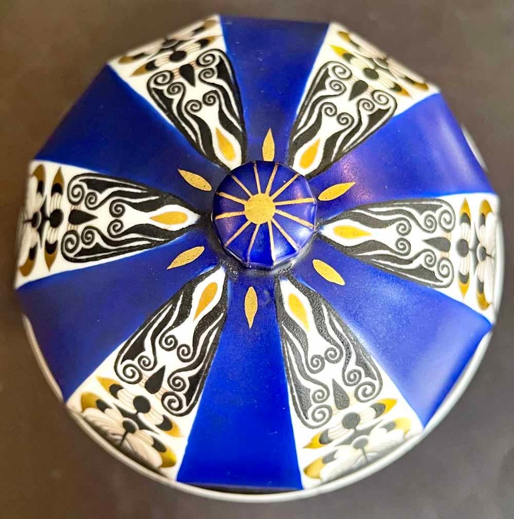 Brilliantly glazed in tones of cobalt, gold, black and white, and decorated with an elaborate geometric pattern overlaid with undulating, organic Art Nouveau motifs, this domed porcelain urn was made by the Fraureuth works in Germany, and reportedly
