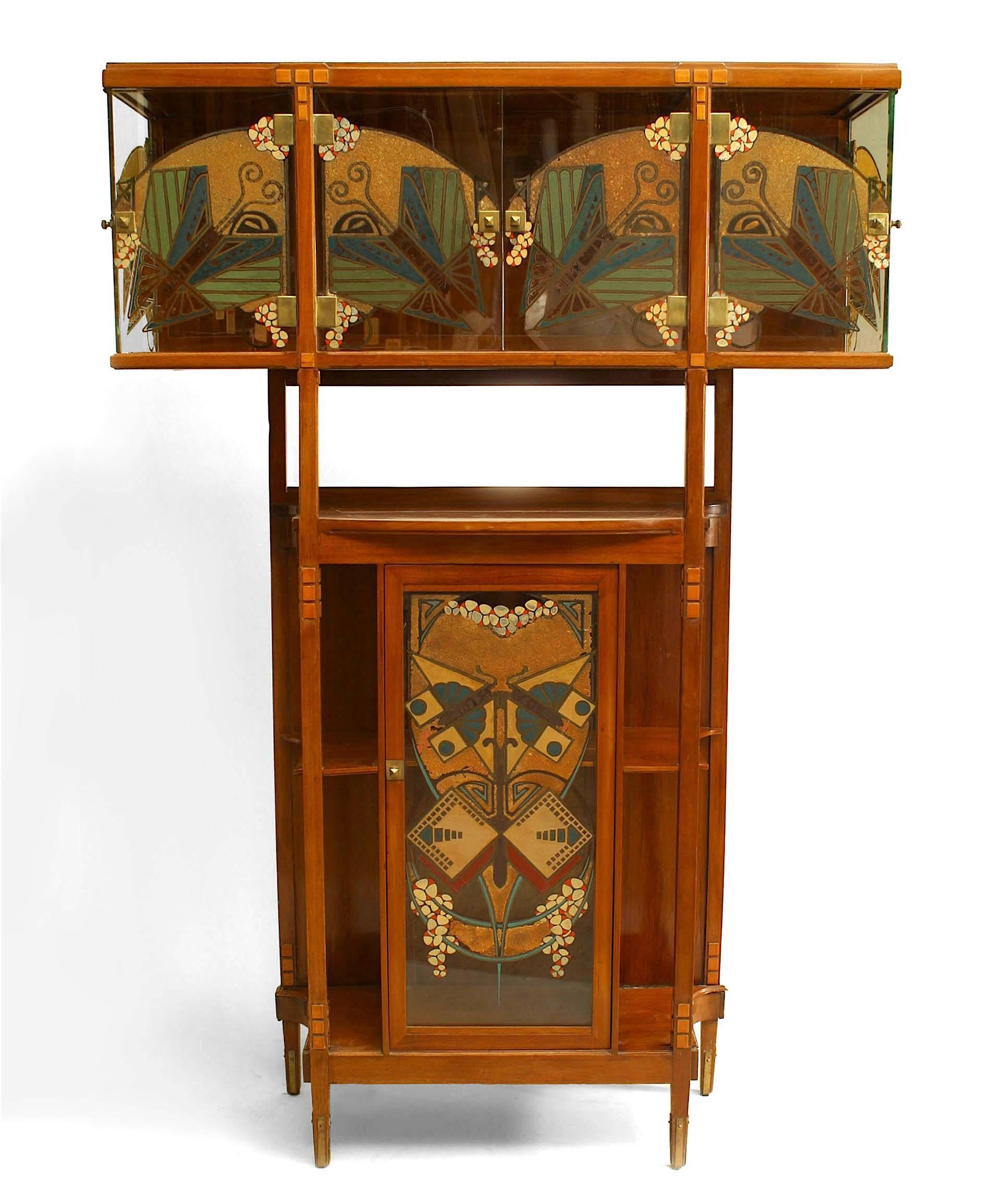 Continental Hungarian Secessionist mahogany and maple cabinet with side shelves and upper section with geometric painted glass door panels.

