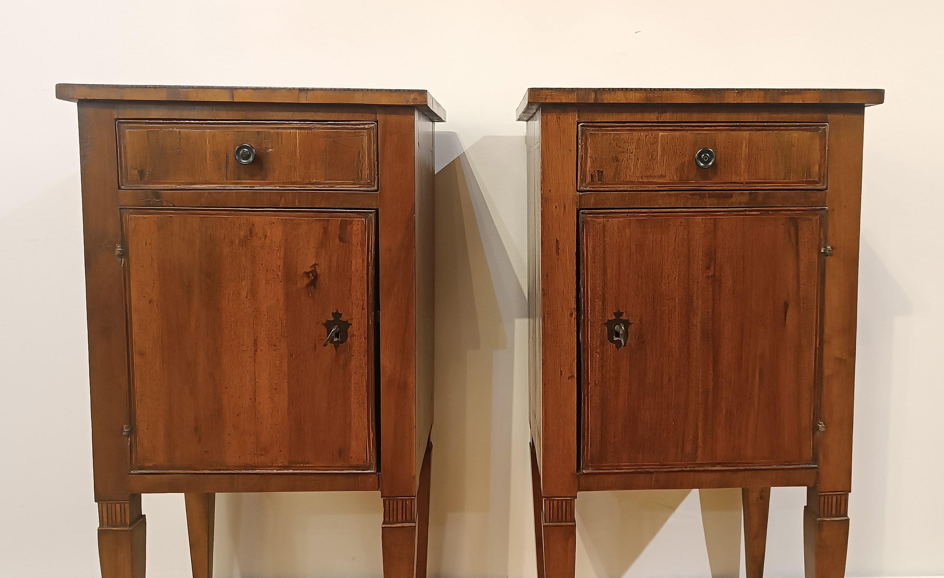 Pair of bedside tables in solid fir wood and walnut veneer. The bedside tables are decorated with geometric inlays in fruit wood and walnut, present on the top and sides, which give a touch of greater elegance. They are equipped with a drawer and a