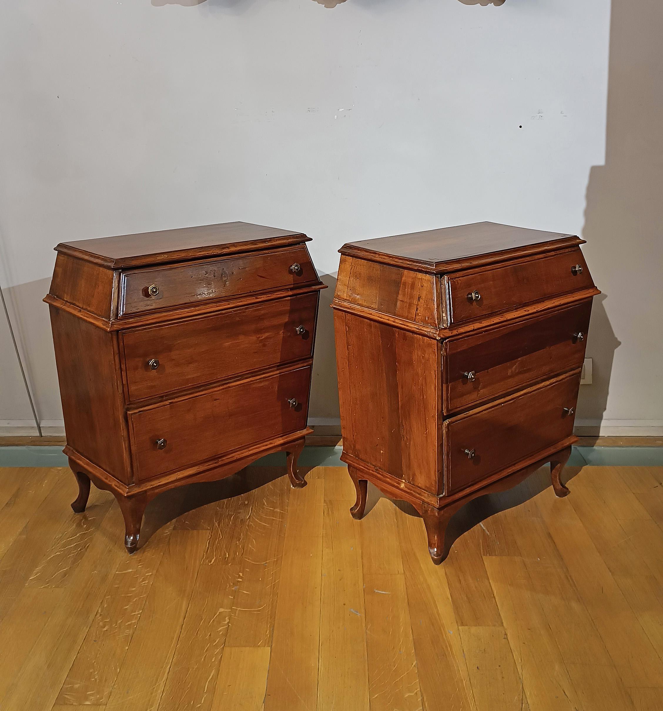 Elegant pair of bedside tables in solid carved blond walnut, characterized by a particular urn shape that makes them truly unique. The top is smooth and has a band under the top, while the feet are slightly curved outwards. The bedside tables are