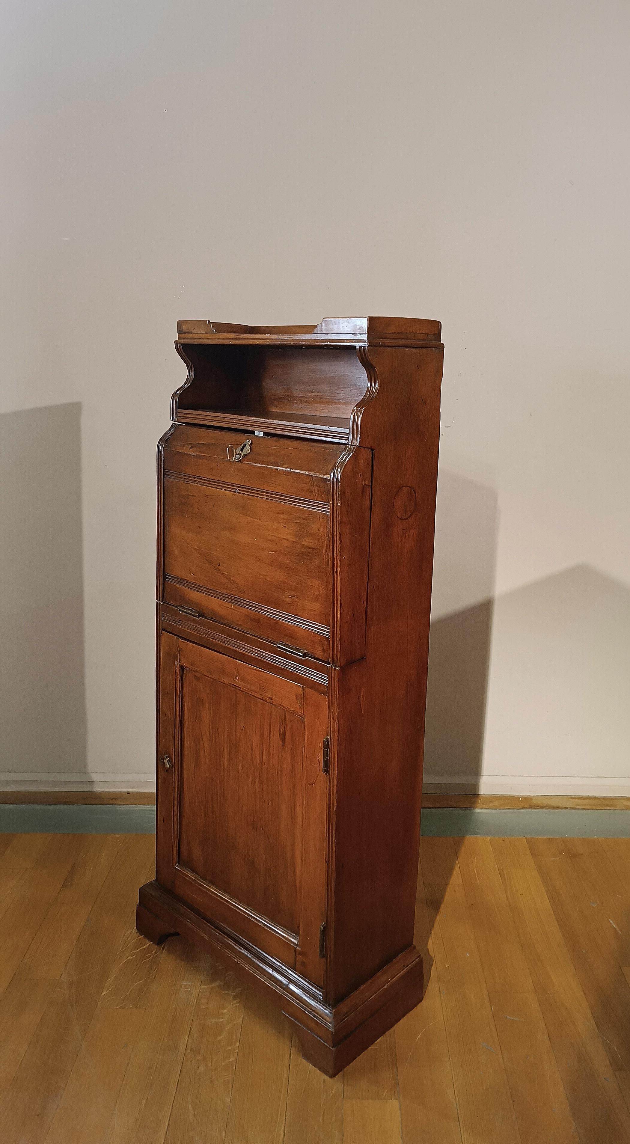 Elegantes Kleinmöbel aus geschnitztem, massivem Nussbaumholz, mit klappbarer Platte zum Schreiben im Stehen. Dieses Möbelstück wurde als Stehpult entworfen, die Oberseite lässt sich mit einem Schloss öffnen und es gibt zwei kleine Regale zur