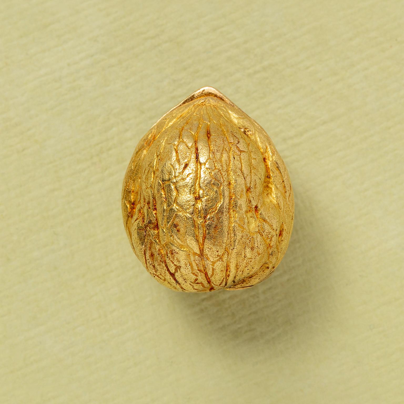 Ein 18kt Gold strukturiert und chiselet Nussbaum enthüllt eine geheime Taschenuhr. Die Uhr hat ein Scharnier und öffnet sich mit einem ausgeklügelten, patentierten System (Nr. 1.345.713). Die Uhr hat ein rundes Gehäuse, ein silbernes Zifferblatt mit