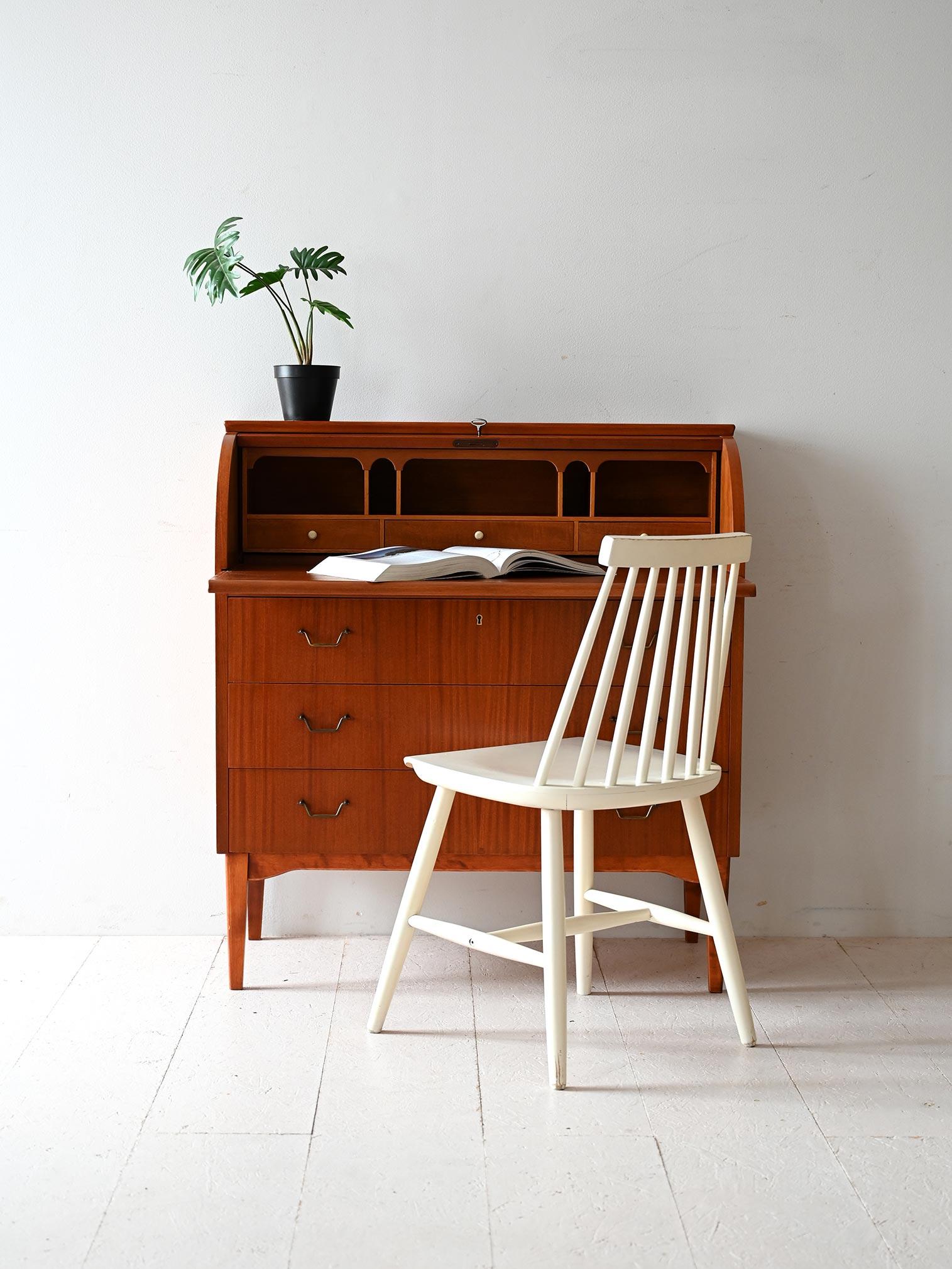 Secretaire in mogano, tre cassetti e scrittoio nascosto. Elegante chiusura a rullo con venature a spina di pesce.

Elegante secretaire svedese degli anni ’50 attribuito a AB Bröderna Gustafsson, completo di etichetta originale. La struttura in
