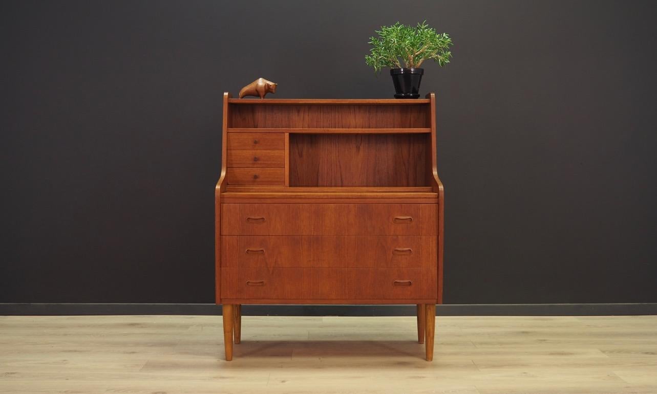 The classic secretaire from the 1960s-1970s. Danish design, Minimalistic form. The surface of the furniture is finished with teak veneer, the top in black. The secretaire has three large and three small drawers, a pull-out top. Maintained in good