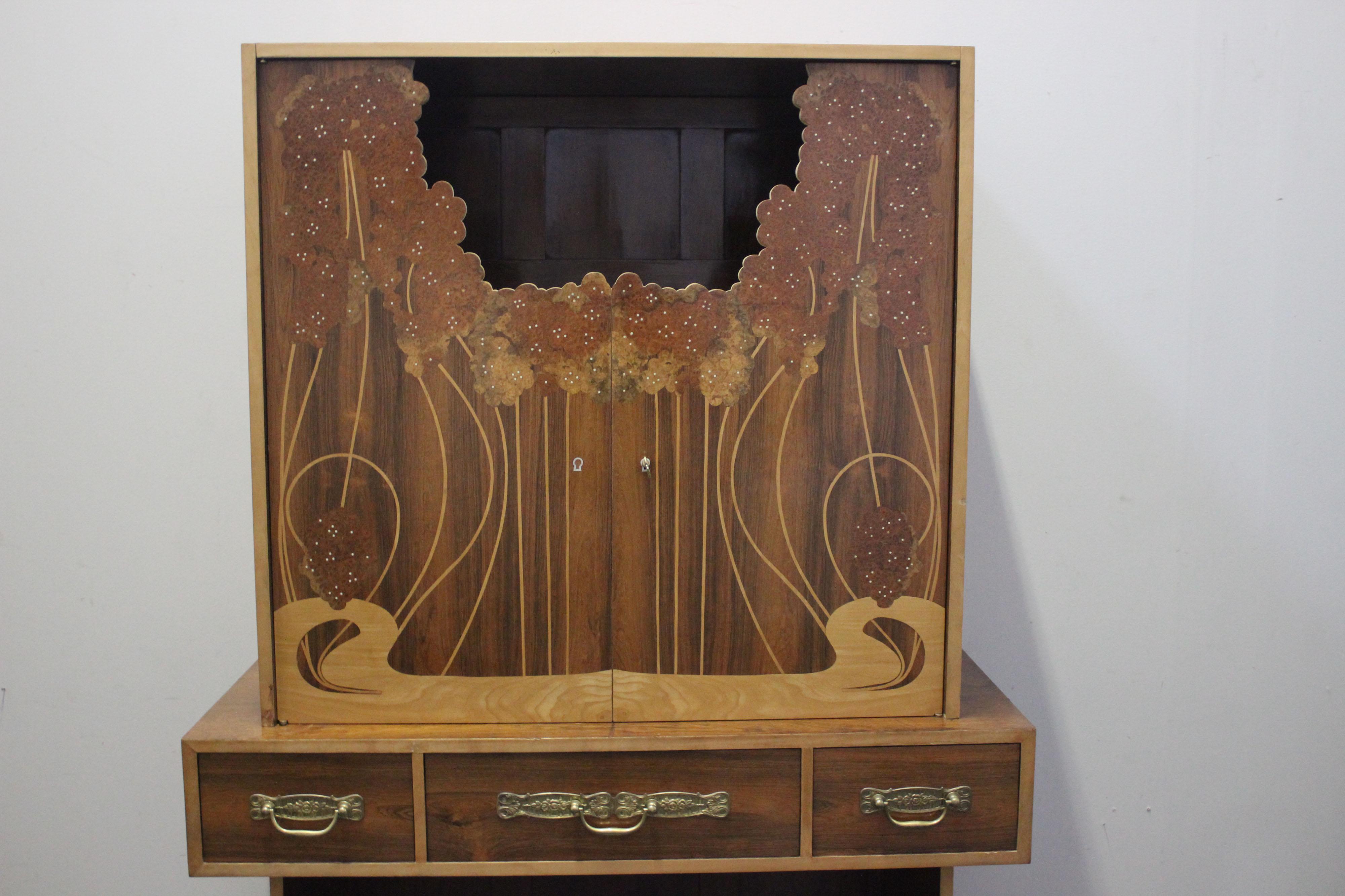 Furniture made of rosewood inlaid with precious briarwood and maple. The furniture is of high bourgeois taste. The contrast of the rigid geometric lines of the body of the furniture that enclose art-nouveau inlays denotes a great cultural level and
