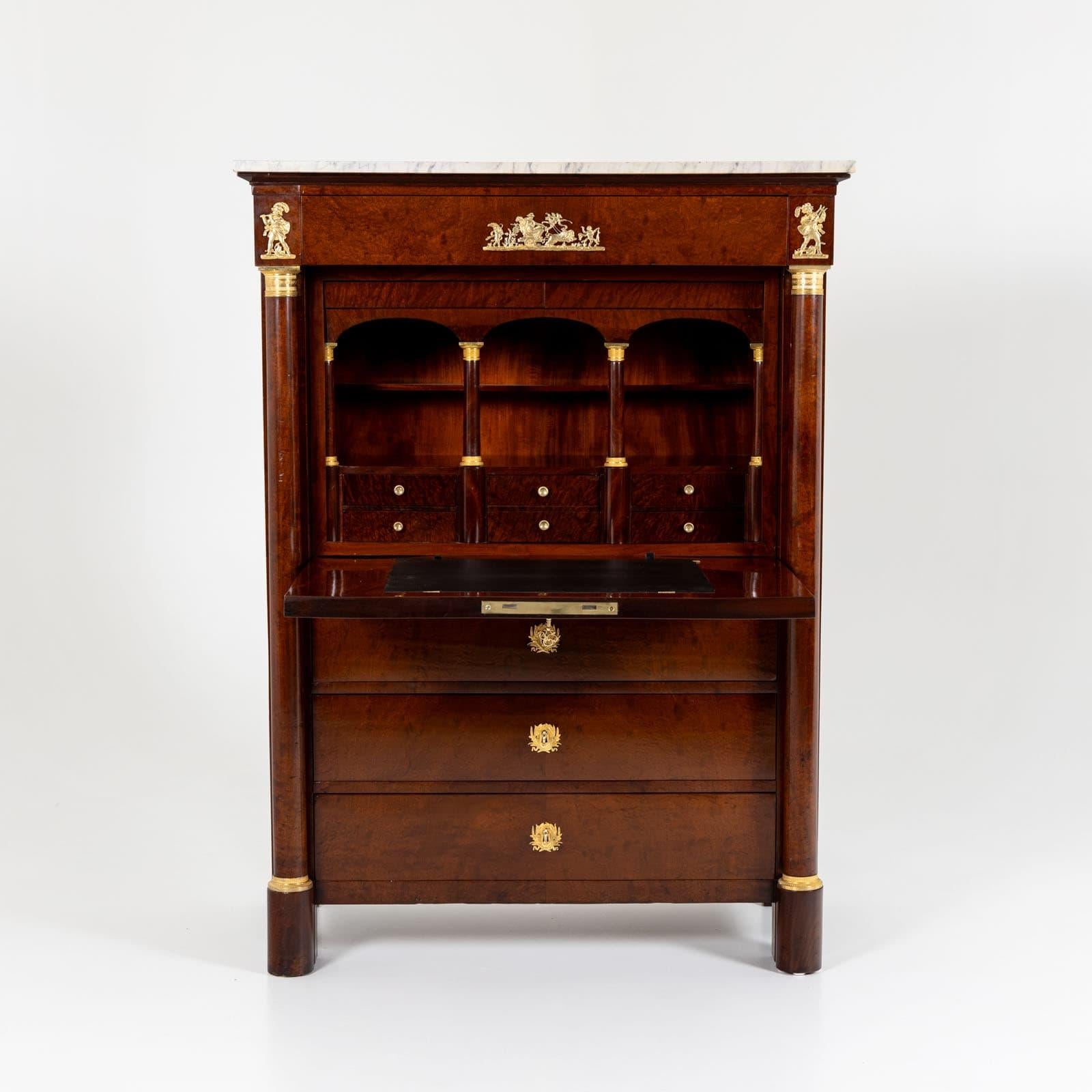 Bureau secrétaire avec plateau en marbre blanc et placage en racine de thuya. La façade du bureau est conçue comme un meuble haut, les trois tiroirs supérieurs formant une porte. En dessous, il y a trois tiroirs supplémentaires et un autre tiroir
