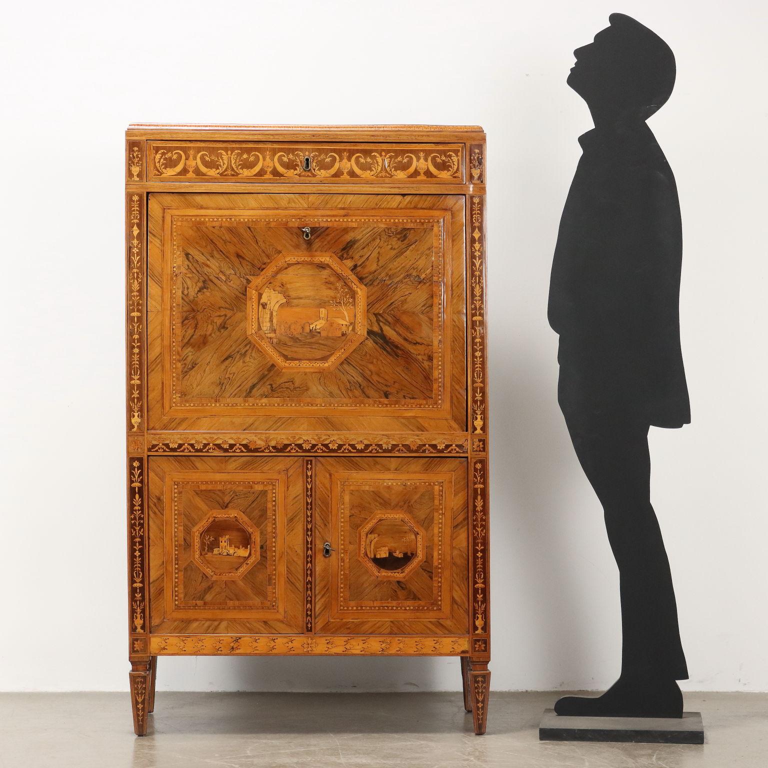 Secretaire neoclassico realizzato alla fine del XVIII secolo. Realizzato con due ante nella base, anta a ribalta con scarabattolo e cassetto sotto piano. Realizzato in noce e poi impiallacciato e intarsiato in essenze varie, tra cui noce, noce