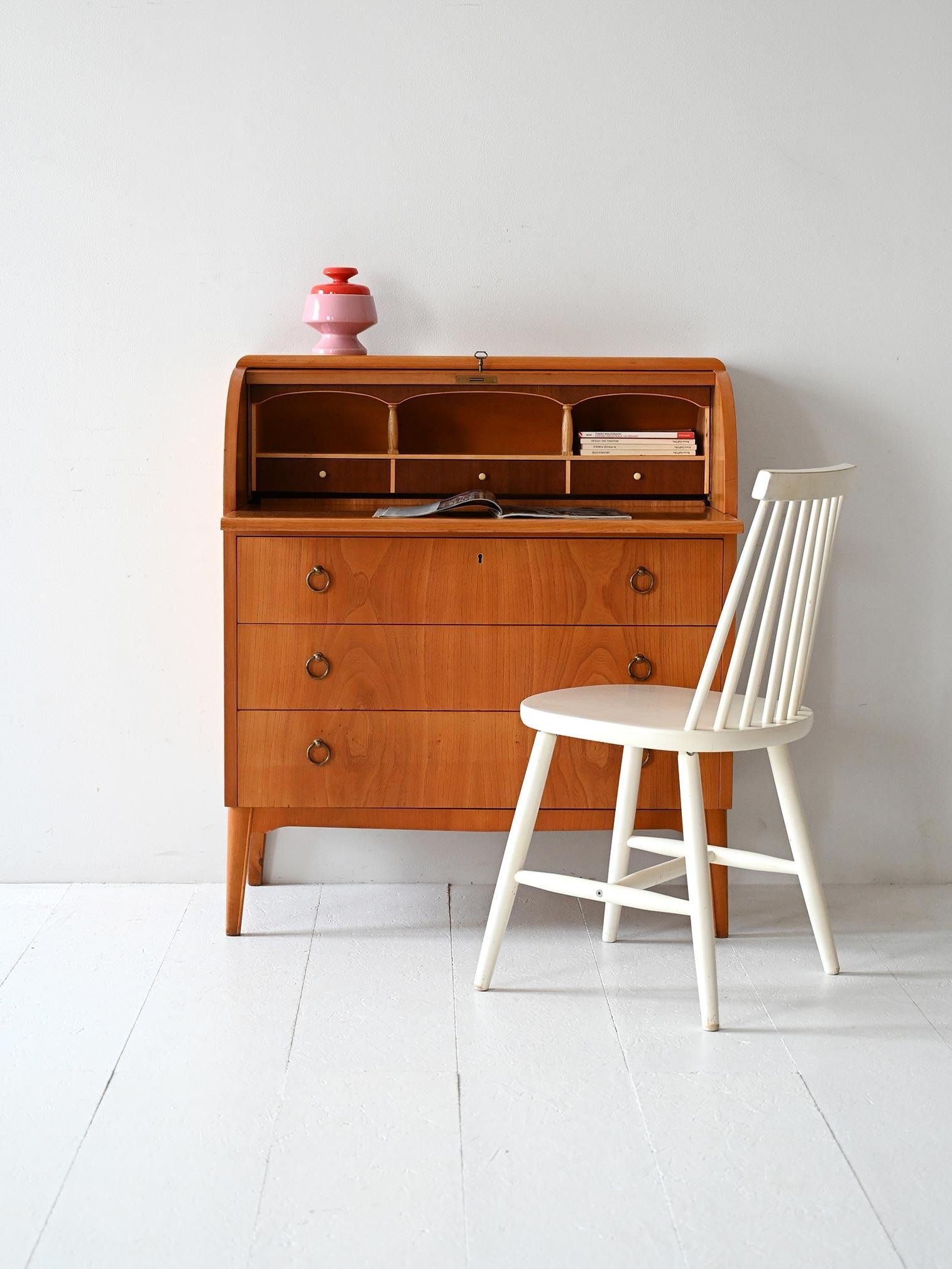 Writing cabinet with drawers and teak flap. The pull-out top turns it into a perfect work surface. 

The frame is made of teak, and the ring handles of the drawers are made of gold metal. The top of the cabinet can remain open or closed as needed. 