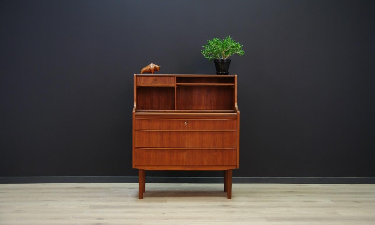 Elegant secretaire from the 1960s-1970s, finished with teak veneer. Item has three drawers, a mirror, compartments and a sliding top. No key in the set. Preserved in good condition (minor scratches and upholstery) - directly for use.

Dimensions: