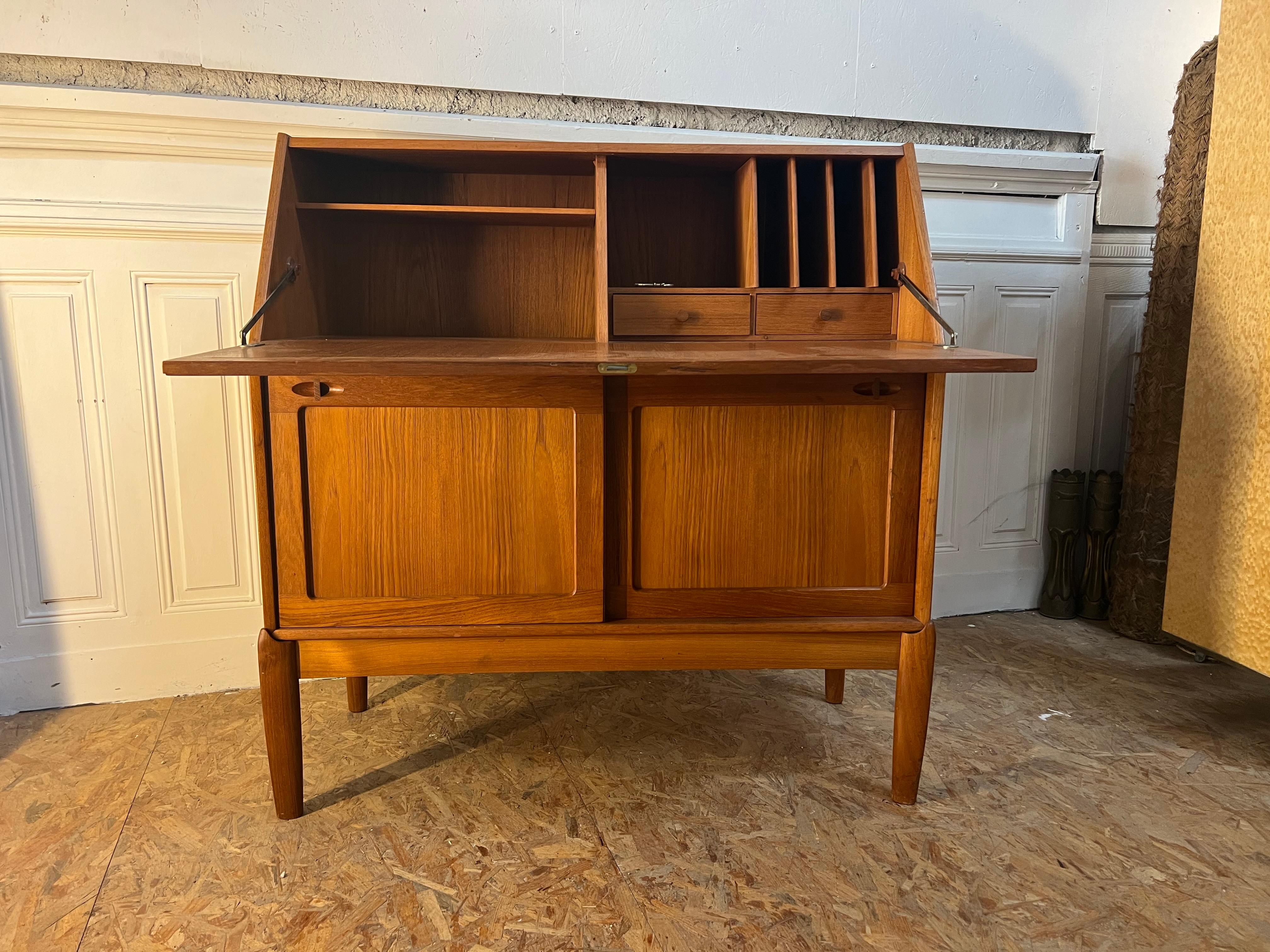  

This beautiful high quality finished Danish compact writing desk cabinet is designed by H.W. Klein for Bramin in the 1960s. It features an extendable writing surface. The teak wooden structure shows an overall warm glow in its wonderful