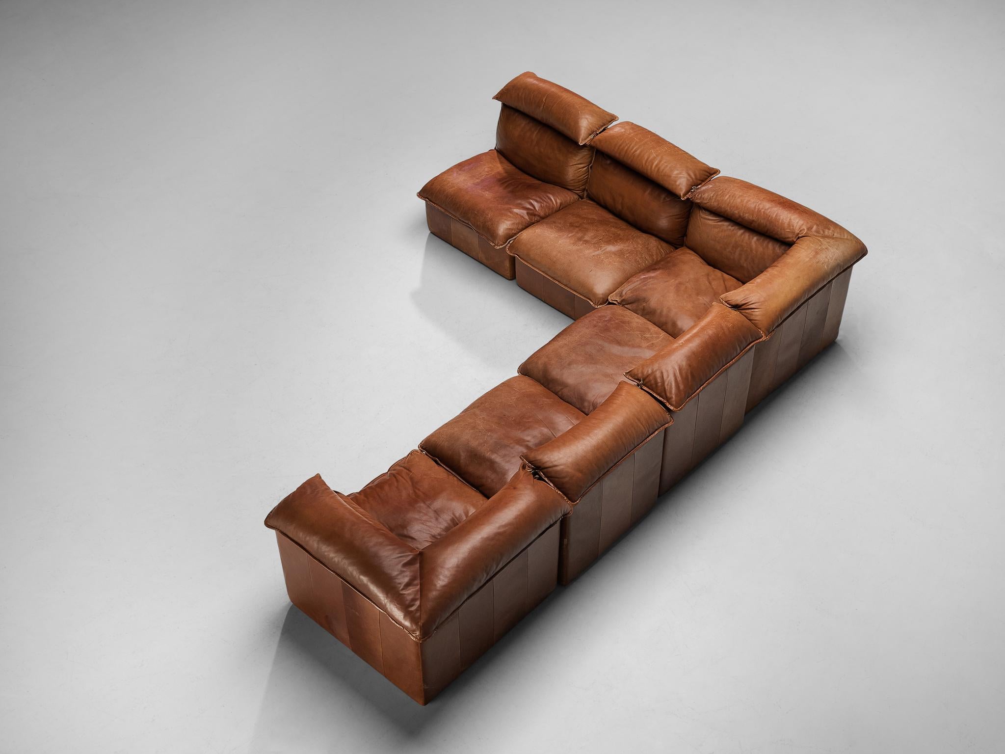 Sectional sofa, leather, Europe, 1970s.

Bulky yet elegant, this well-designed sofa is executed in warm cognac leather with age-appropriate, admirable patina that gives this piece of furniture a strong and naturalistic character. This sofa is