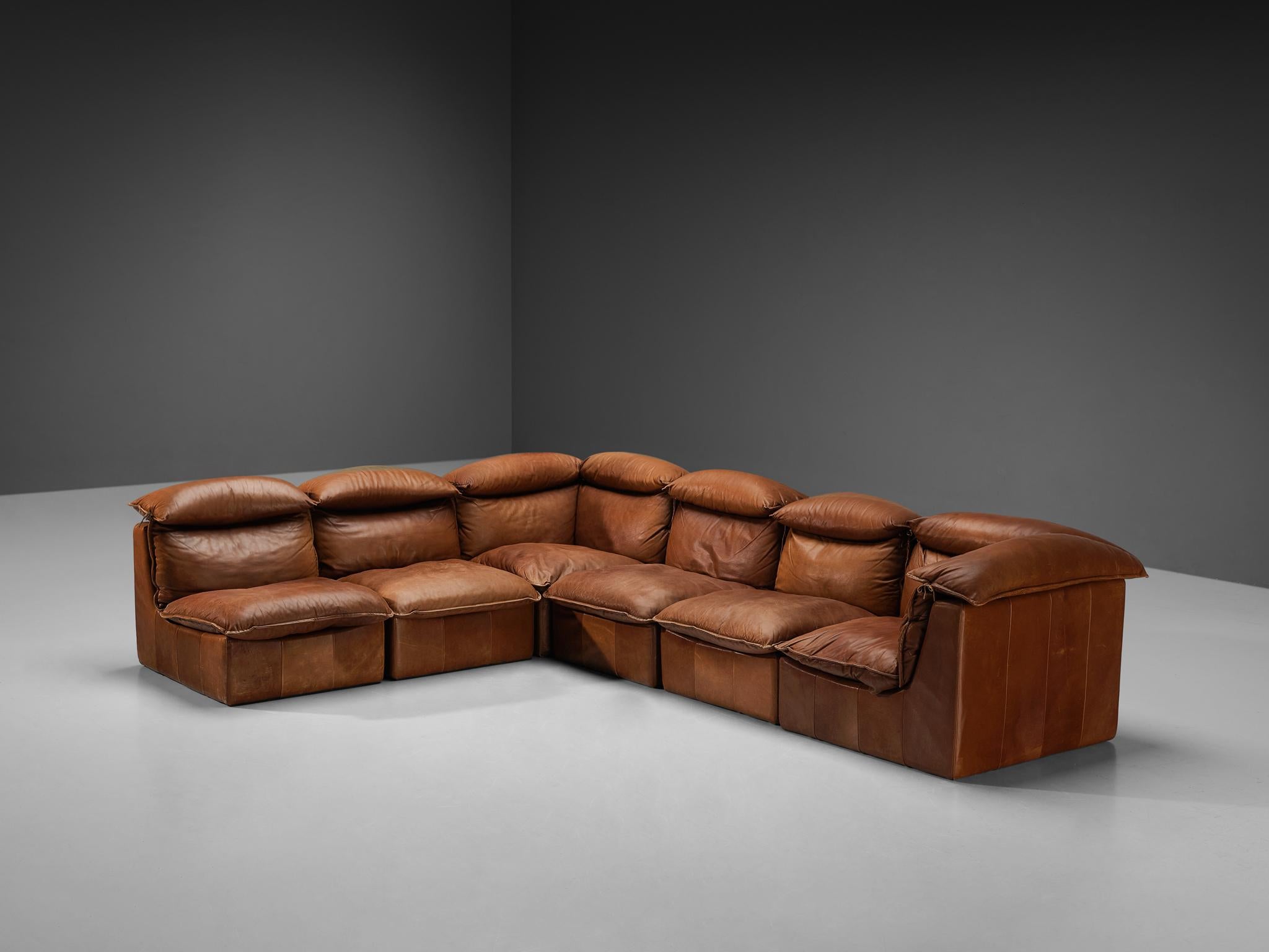 Sectional sofa, leather, Europe, 1970s.

Bulky yet elegant, this well-designed sofa is executed in warm cognac leather with admirable patina that gives this piece of furniture a strong and naturalistic character. This sofa is characterized by a