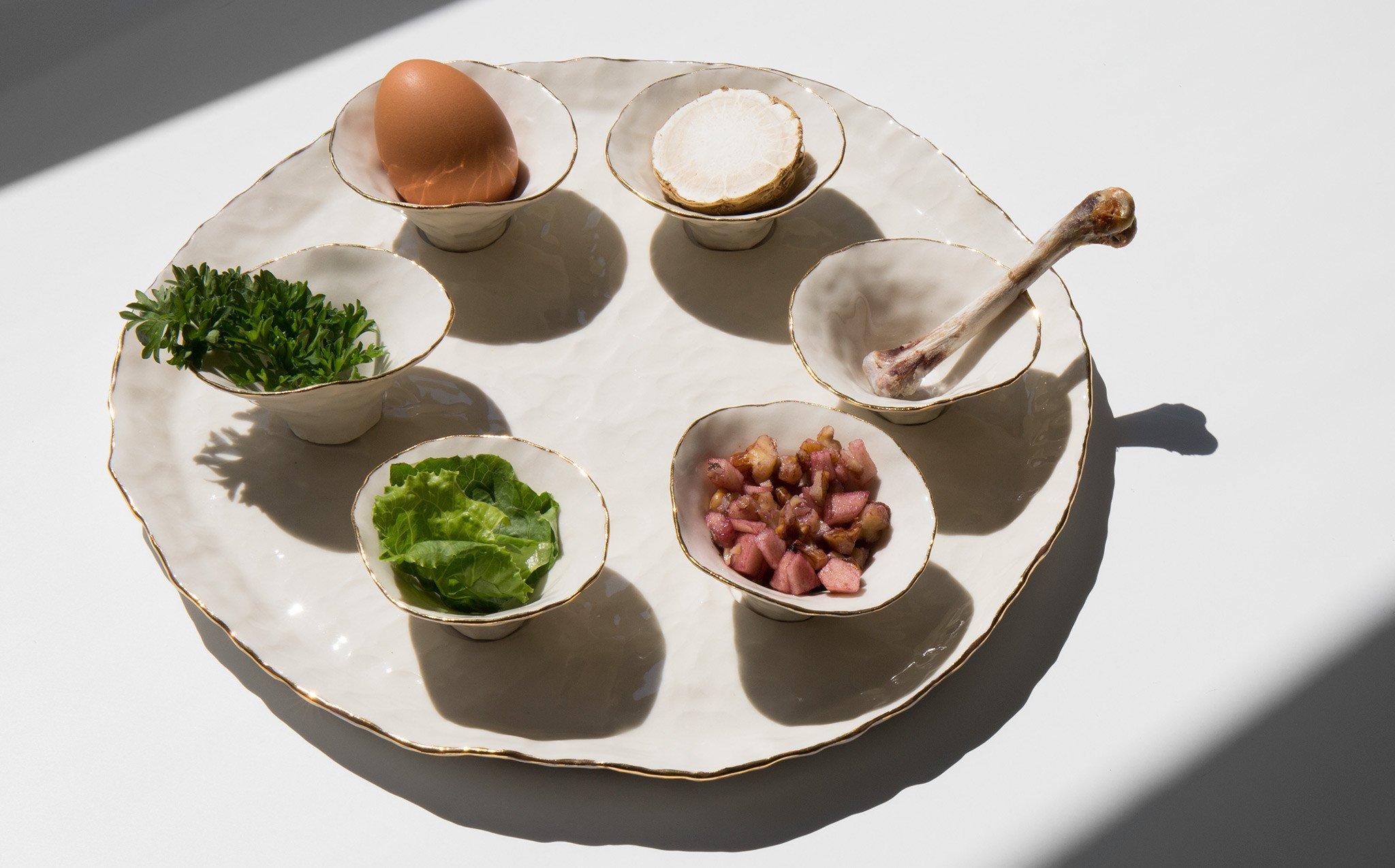 Each Seder plate by Isabel Halley has six pinch pots to hold the six symbolic foods used in the ritual meal. All six pinch pots are clear glazed and lined with a 22-karat gold luster. 

The plate has six indentations for each pot to nestle into.