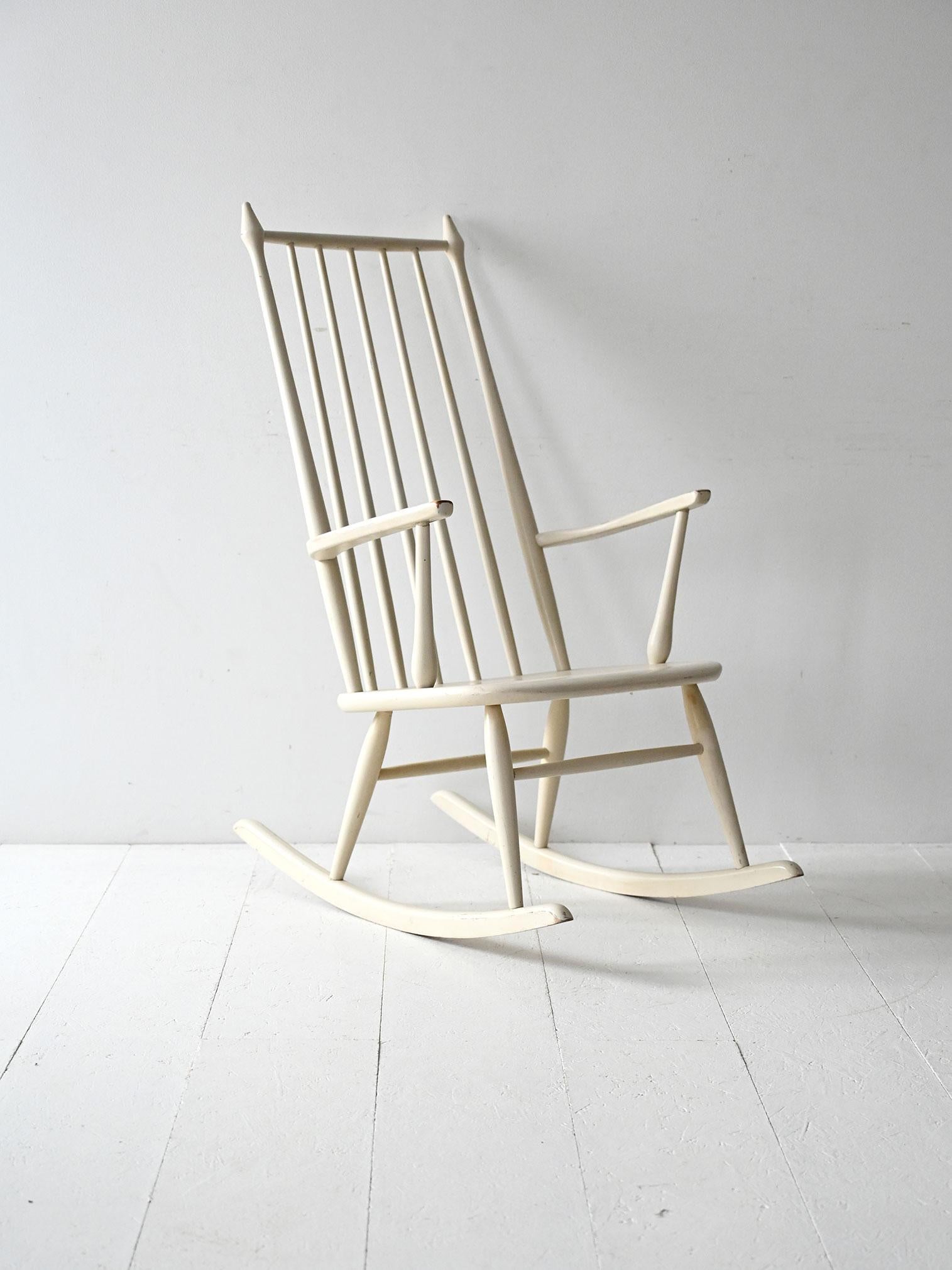 Sedia a dondolo scandinava anni ’50 in legno laccato bianco. Linee semplici con dettagli decorativi nella parte superiore dello schienale.

Sedia a dondolo scandinava vintage degli anni ’50, realizzata in legno laccato bianco. Lo schienale alto a