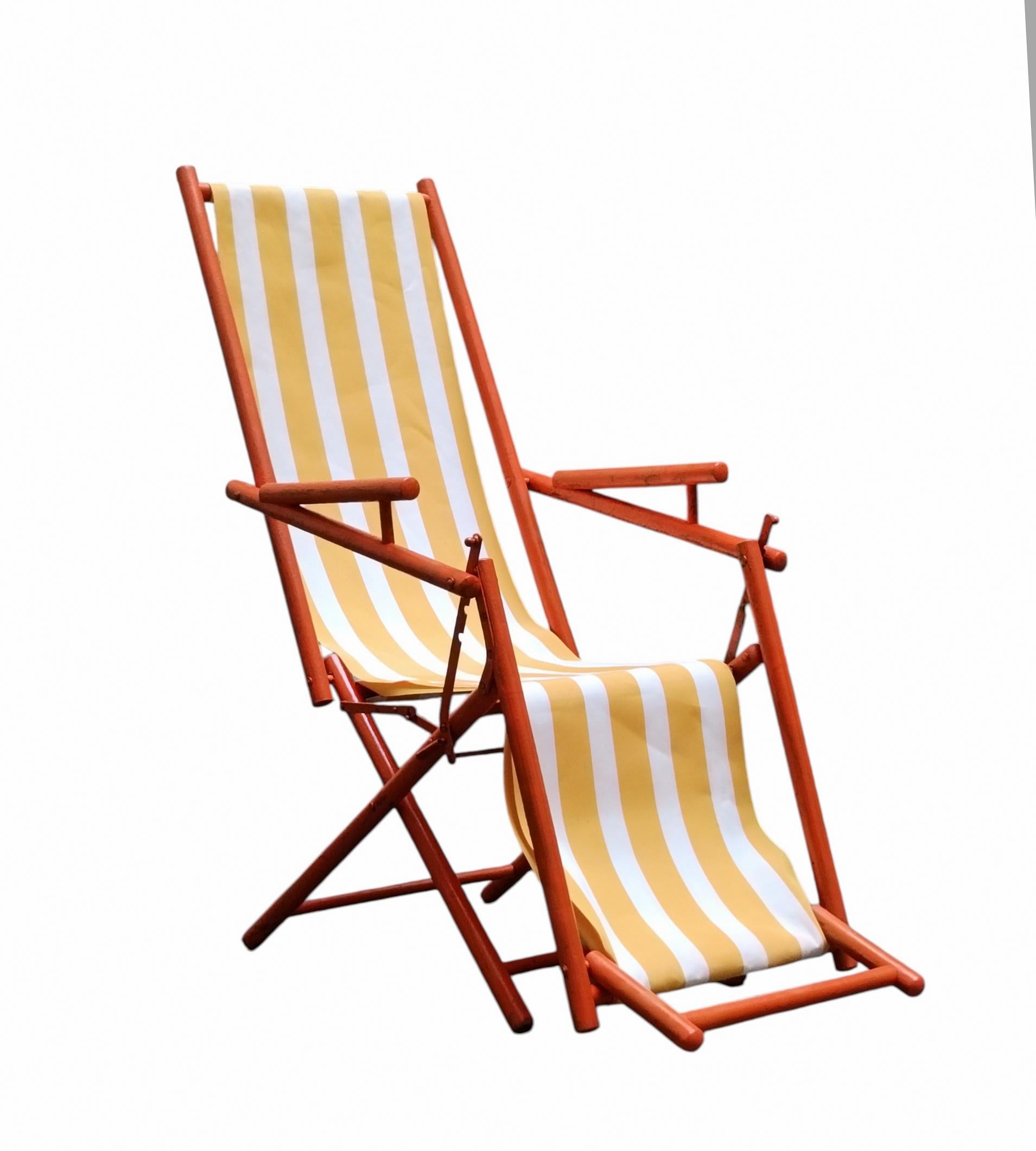 Tumbona plegable y reclinable con estructura de madera y tela a rayas, completa con reposapiés. La chaise longue  es una auténtica maravilla que recuerda la elegancia y el encanto de los camarotes de primera clase de los cruceros de principios del