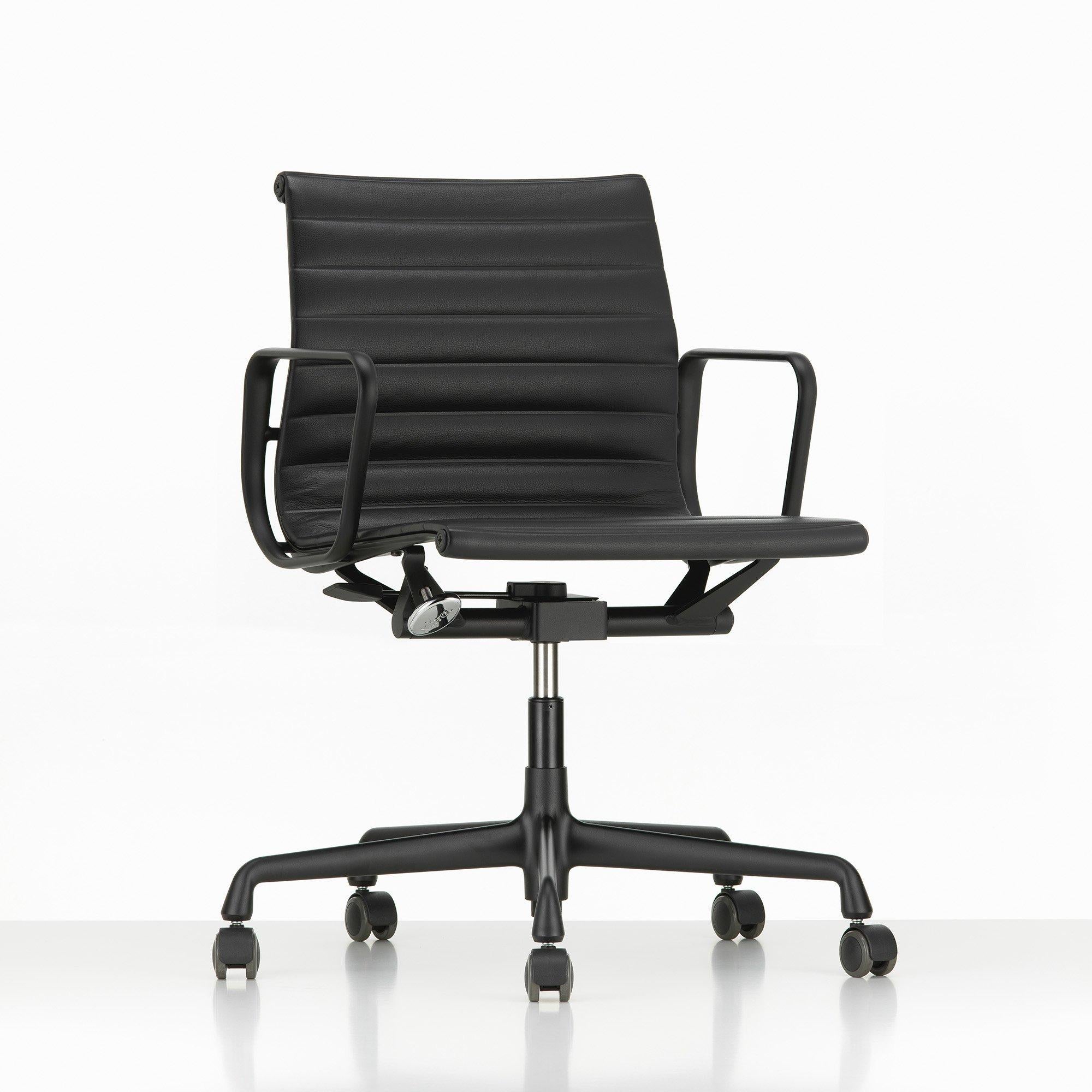 Chaise de bureau Ea 117 conçue par Charles et Ray Eames et produite par Vitra en 1999. Le siège a une structure en aluminium et fait partie de la grande famille des sièges de travail de l'Aluminium Group. Son revêtement en cuir noir confère une