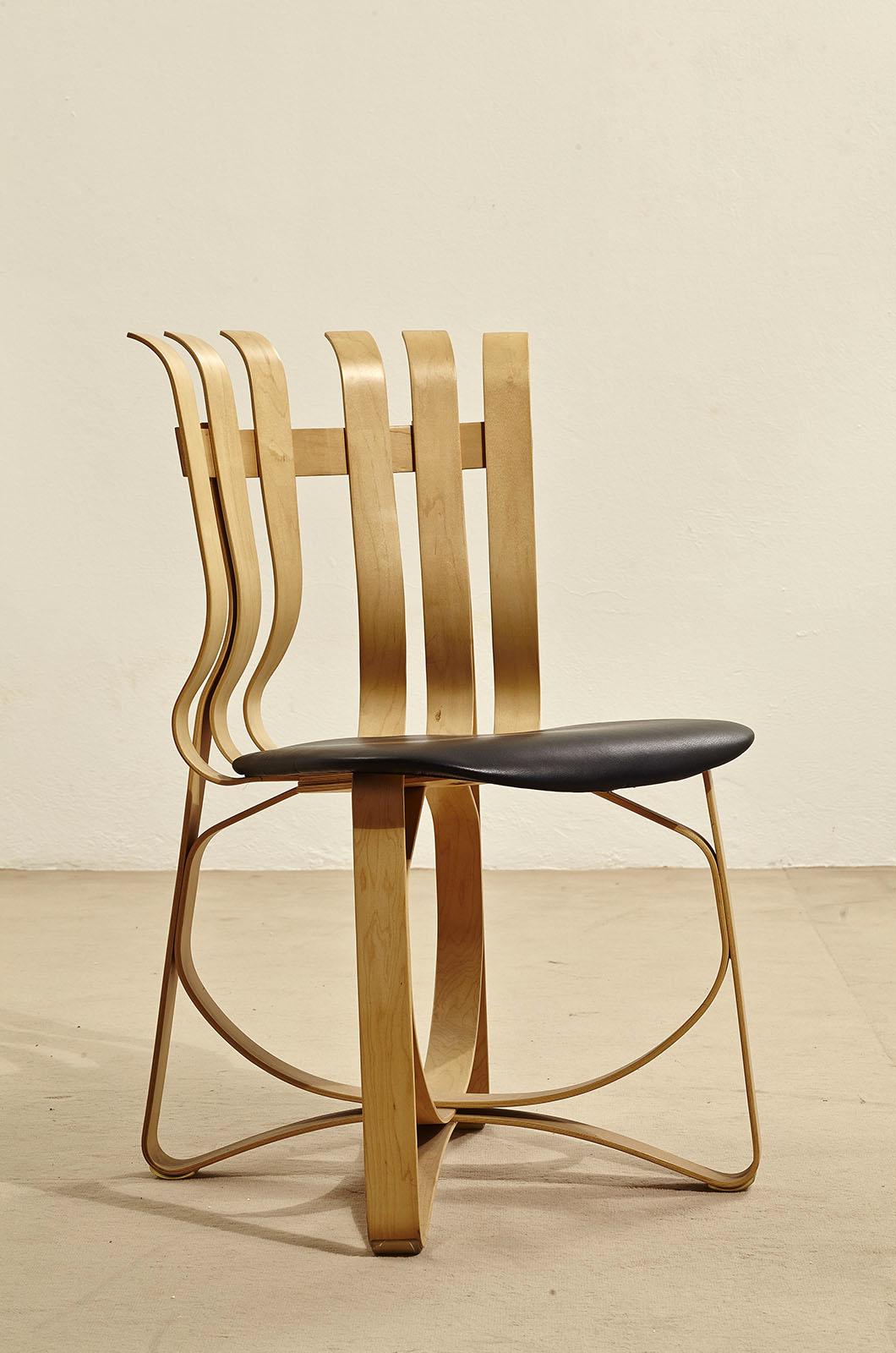 The Hat Trick chair, designed by Frank Gehry for Knoll, features a distinctive striped frame of natural maple.  The soft shape of the frame is complemented by a padded cushion in the seat area for added comfort. Branded. The chair is made entirely