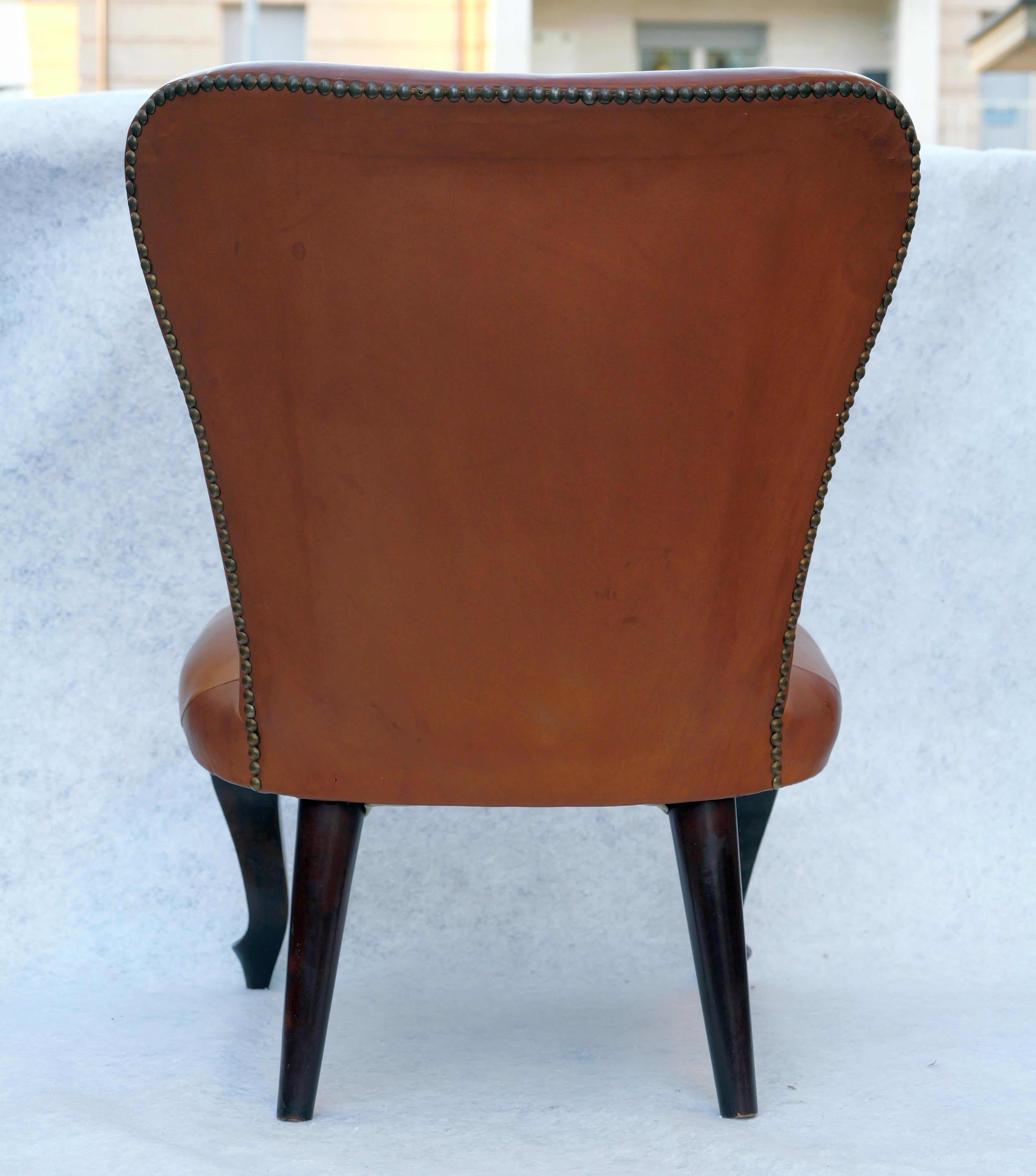 Sedia in pelle, Made in Italy, Anni '40. 
Particolare Sedia con schienale e seduta sagomata in pelle Originale che poggia su gambe anteriori intagliate. Rivestita in pelle color cuoio e finiture nel retro con chiodini in ottone. E' tutto ORIGINALE e