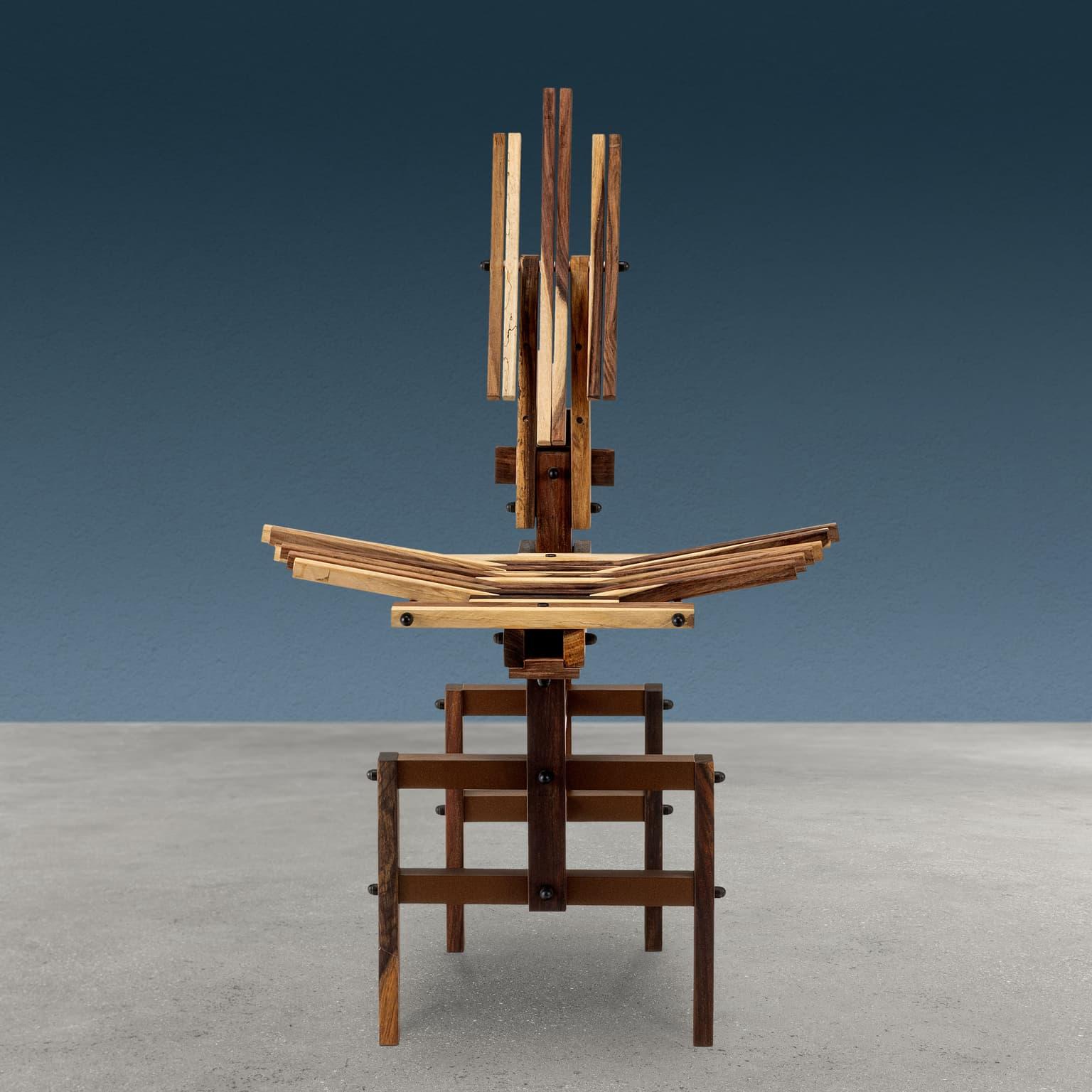 Sedia scultorea disegnata e realizzata da Anacleto Spazzapan mediante la giuntura di listelli di legno di differenti misure e tonalità. Riporta la sigla AS del designer e presenta lo schienale regolabile.	