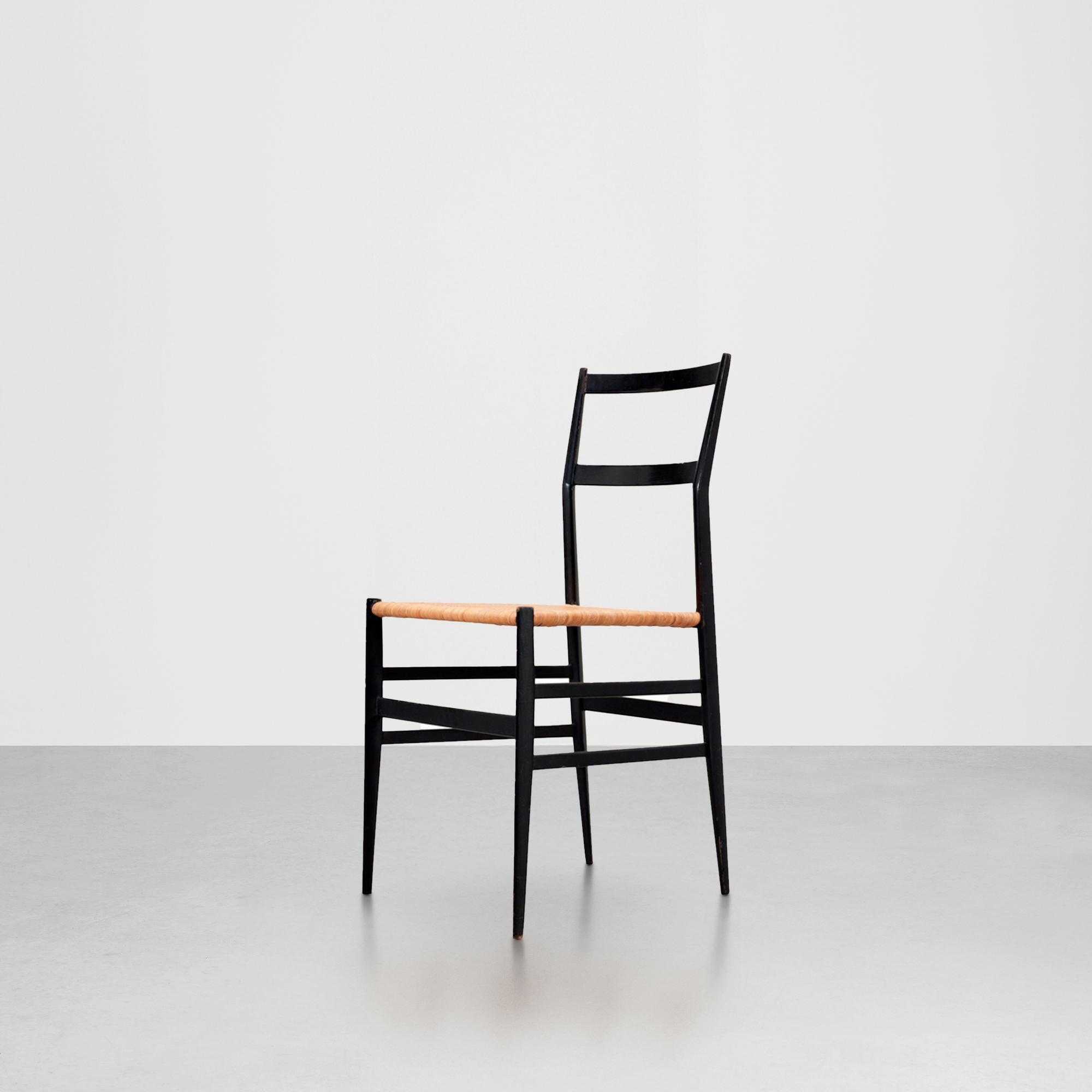 Chaise Superleggera 699 conçue par Gio Ponti en 1957 et produite par Cassina. Sa structure en frêne laqué noir et son assise en canne de Guinée font de cette chaise l'une des icônes les plus célèbres du design. Sa simplicité et son esthétique sont