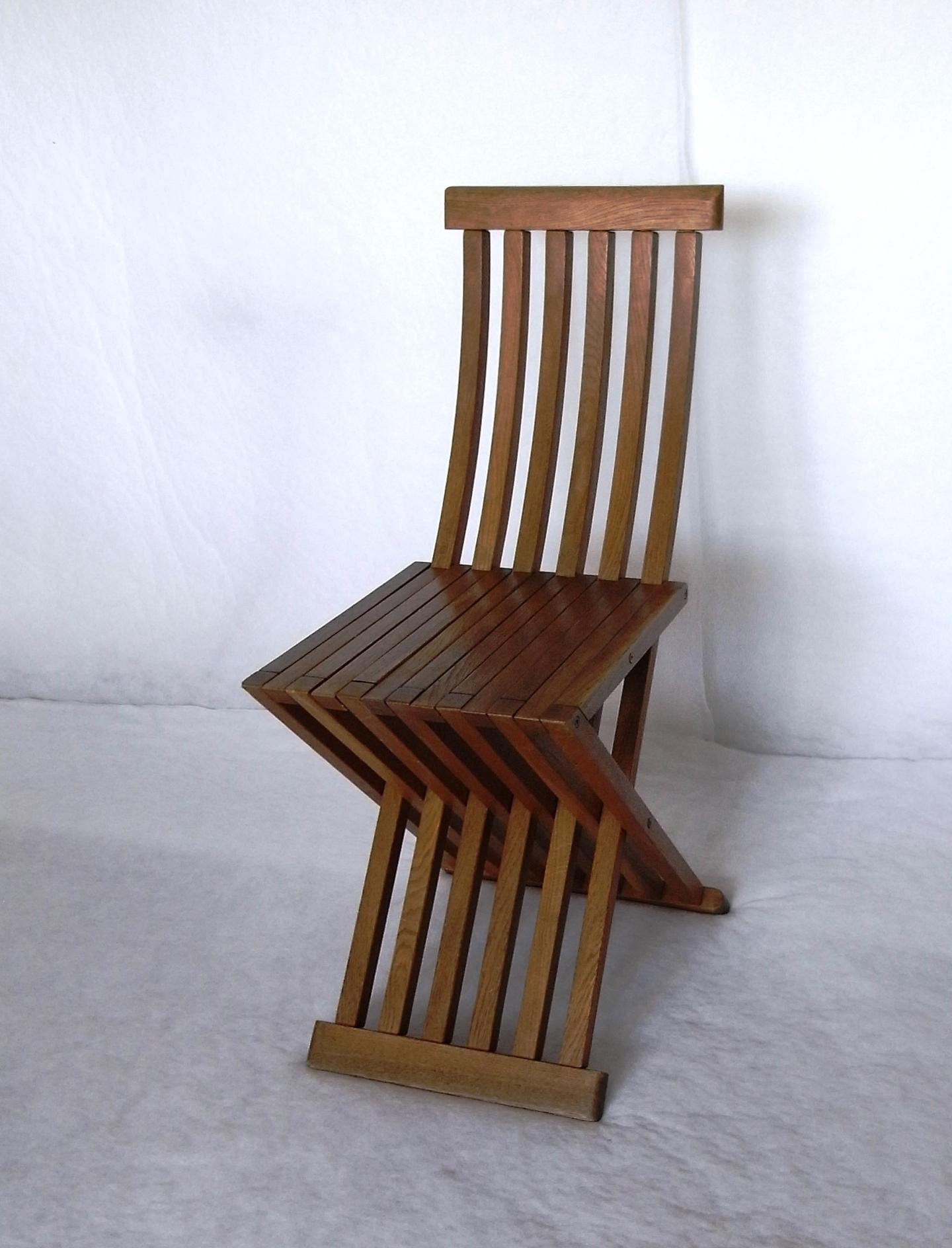 La sedia Tomasa disegnata da Anonimo in omaggio a Paolo Uccello è una sedia pieghevole con schienale e seduta in listelli di rovere massello curvato, con finitura a cera. Gli elementi sono collegati tramite barre e inserti terminali filettati in