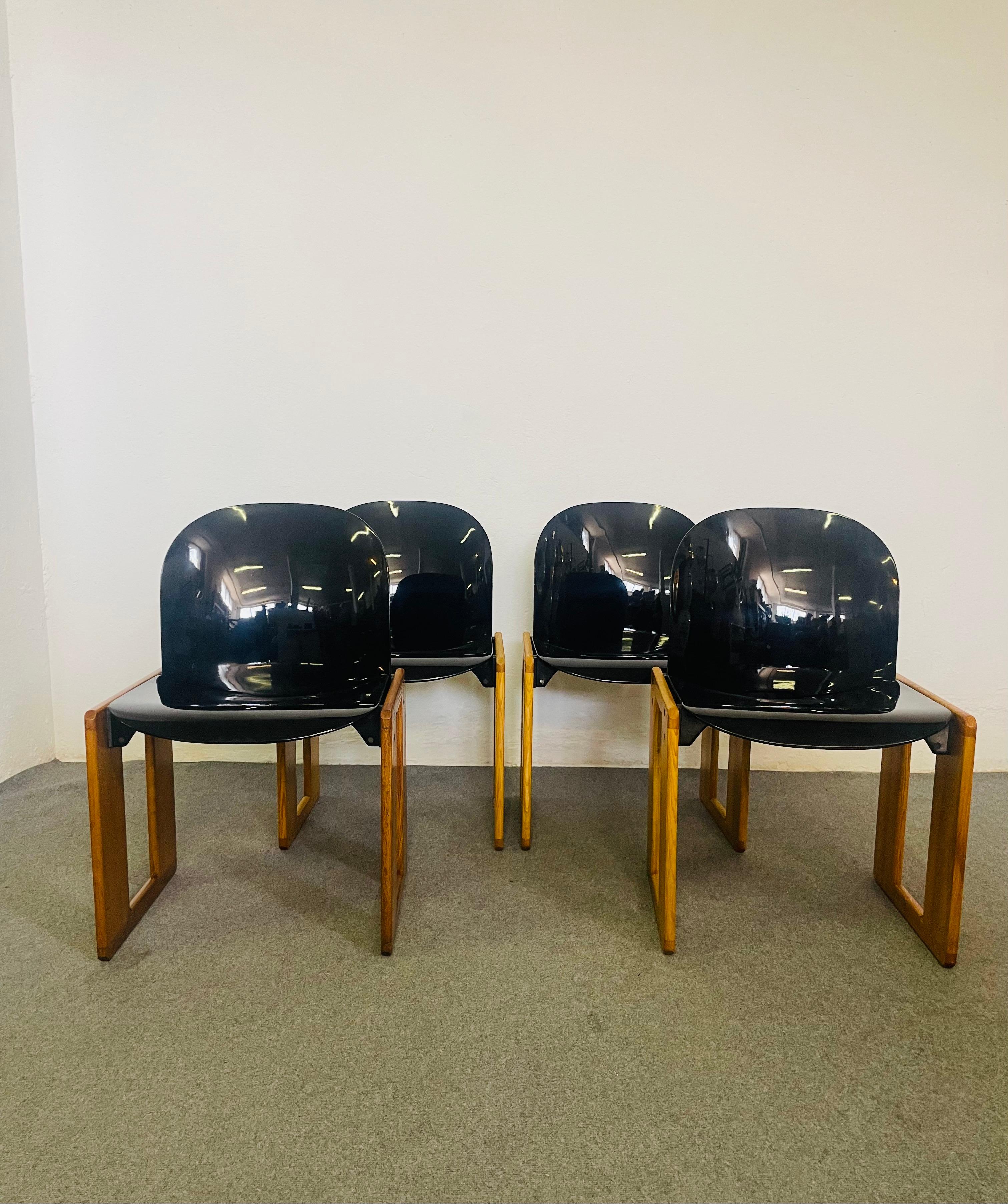 Sedie in plastica e legno Dialogo di Tobia Scarpa per B&B, anni Settanta. Set di quattro sedie Dialogo in plastica e legno. La seduta e lo schienale in plastica nera sono leggermente curvati. I braccioli rettangolari sono in legno massiccio.
