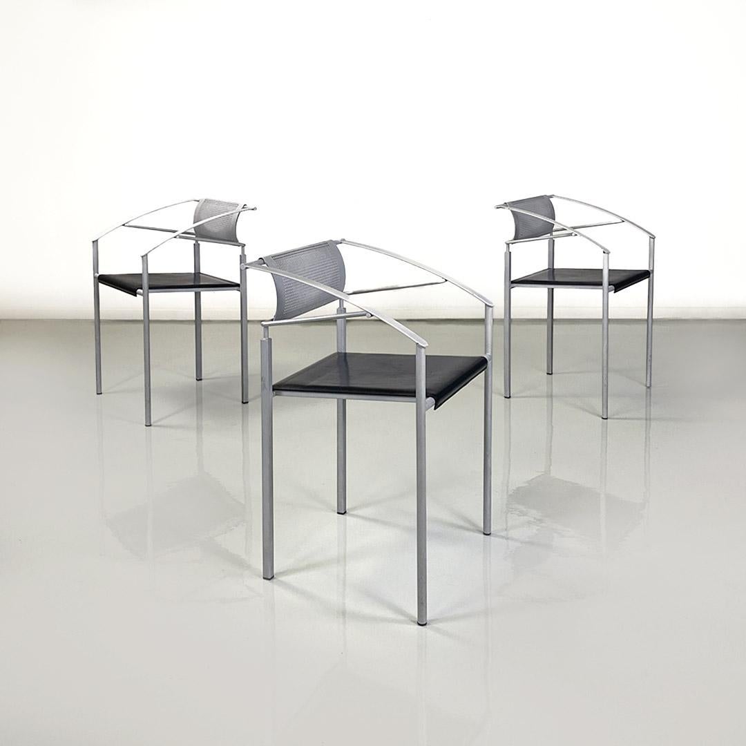 Set of three stackable chairs with armrests with square seat in black leather. The frame is made of light gray painted iron tending to white, with a rectangular, slightly curved, perforated back. The arms are two curved iron strips, while the legs