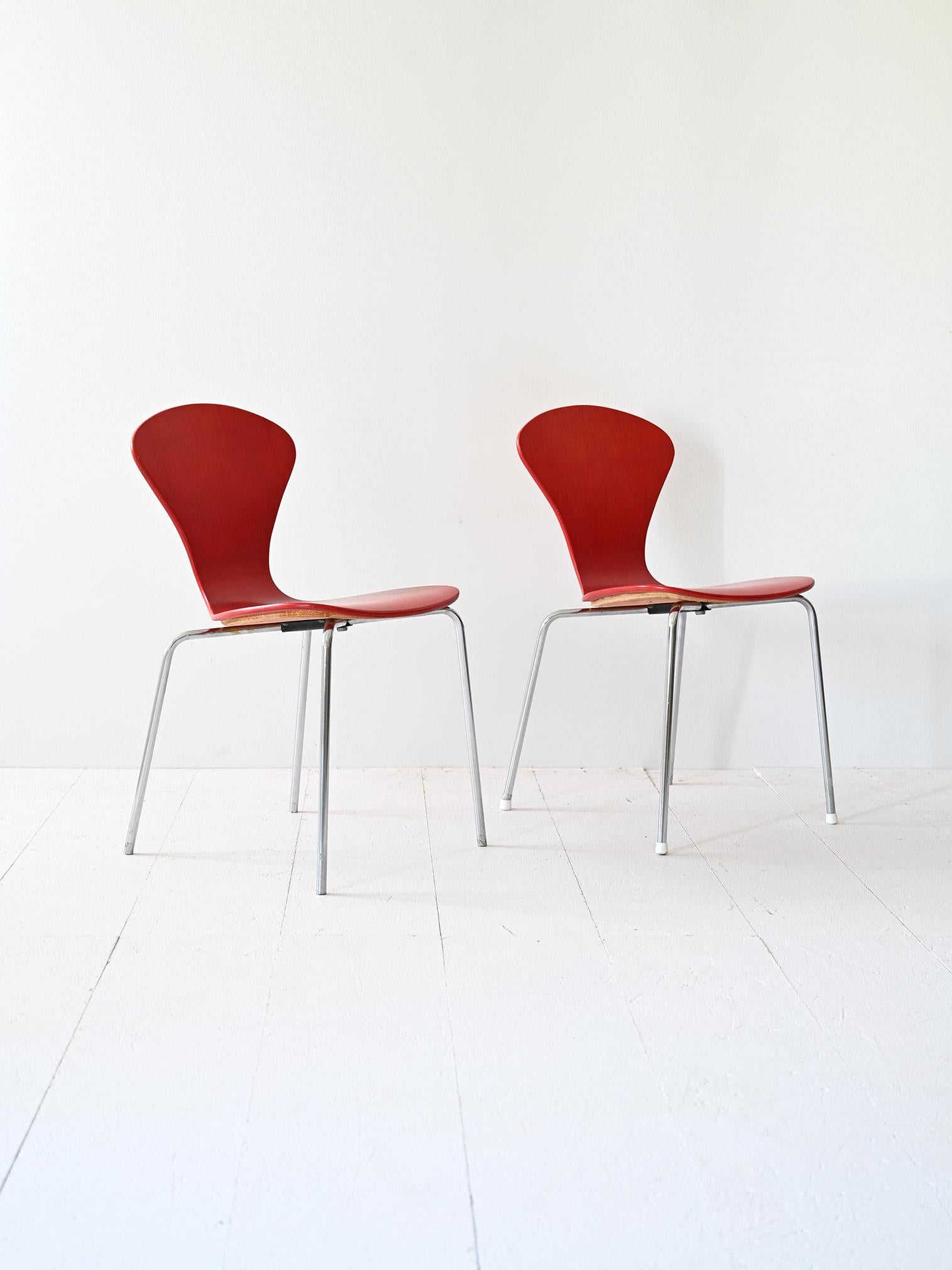 Ein Paar originaler Lennart Bender-Stühle mit einem unverwechselbaren Design mit Metallrohrbeinen und einer rot gestrichenen Holzsitzfläche und -lehne.
Die Metallrohrbeine sorgen für eine solide Struktur und ein schlankes Erscheinungsbild, während