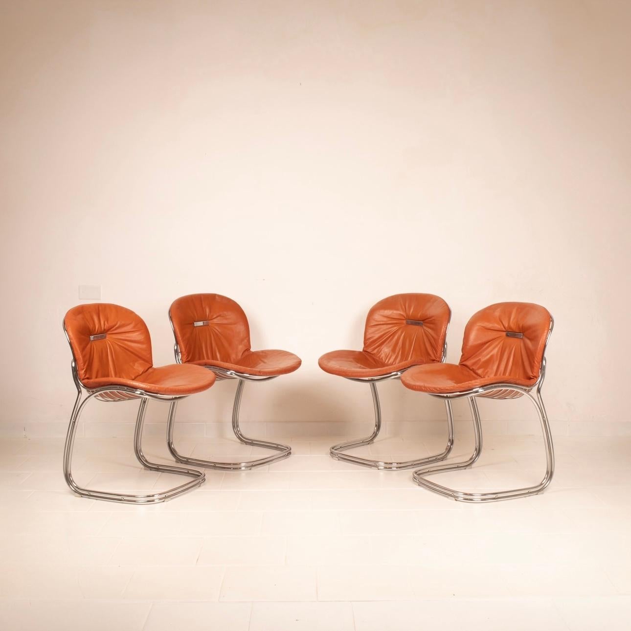 Bellissimo e iconico set di 4 sedie Sabrina disegnate da Gastone e Giorgio Rinaldi per l'azienda Rima di Desio negli anni 70.
Il set si presenta in ottime condizioni vintage completo dei cuscini originali in pelle color tabacco, con qualche