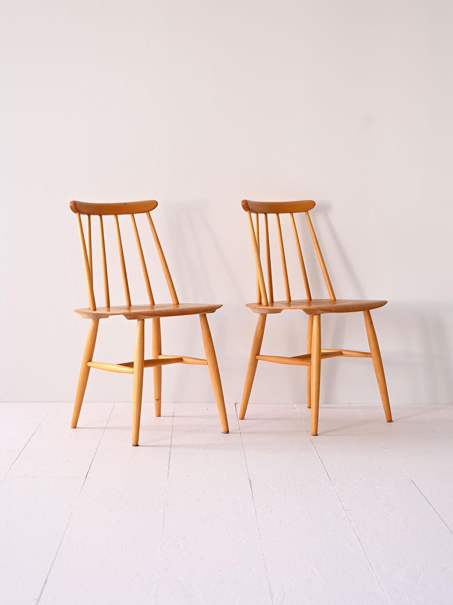 Ein Paar skandinavische Holzstühle im Vintage-Stil, mit einem Gestell aus Birke und einer Sitzfläche aus Teakholz, die sich durch eine Rückenlehne mit Holzstämmen auszeichnet. Sie verkörpern den traditionellen nordischen Stil.

Diese Stühle sind ein