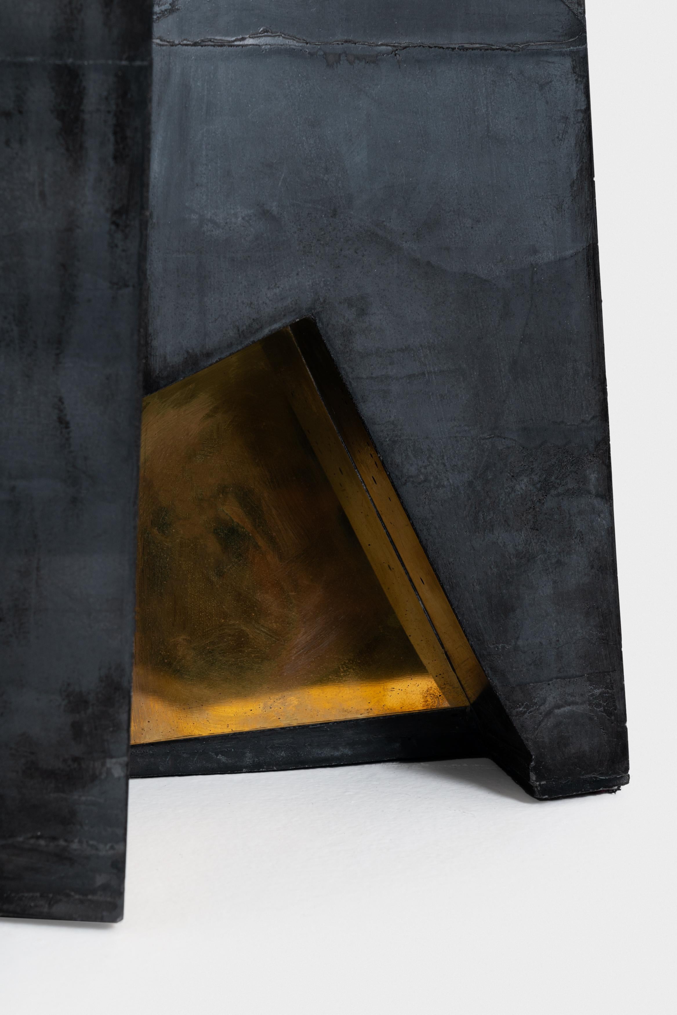The concrete blocks place themselves in between furniture and the architectural elements. Lines left on the surface by the pouring technic are then shadows of the surrounding. Polished brass inserts also play with light and with both the surrounding