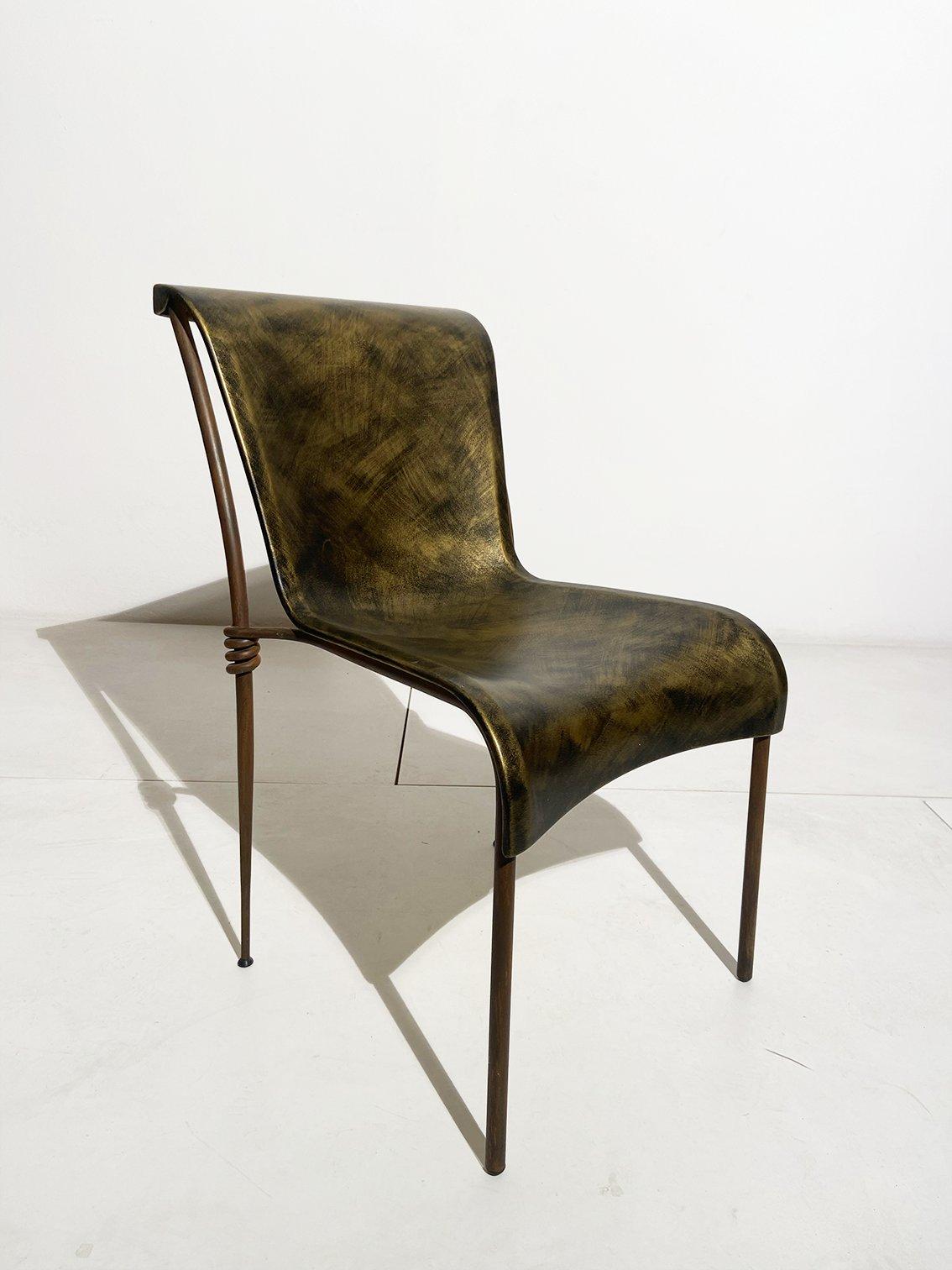 Chaise de bureau produite par Rudebravo en 1990. Sa structure métallique est mise en valeur par la qualité des détails. Les nœuds dans la partie de rencontre de l'assise enrichissent la beauté esthétique de la chaise, ainsi que la coque en résine