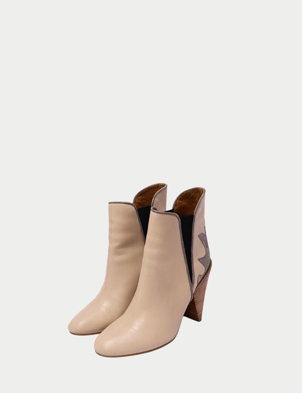 Adéntrate en la elegancia contemporánea con estos botines See by Chloé, confeccionados en suave piel beige con característicos paneles de ante en contraste e inserciones elásticas laterales. Con punta puntiaguda y tacón en bloque de madera