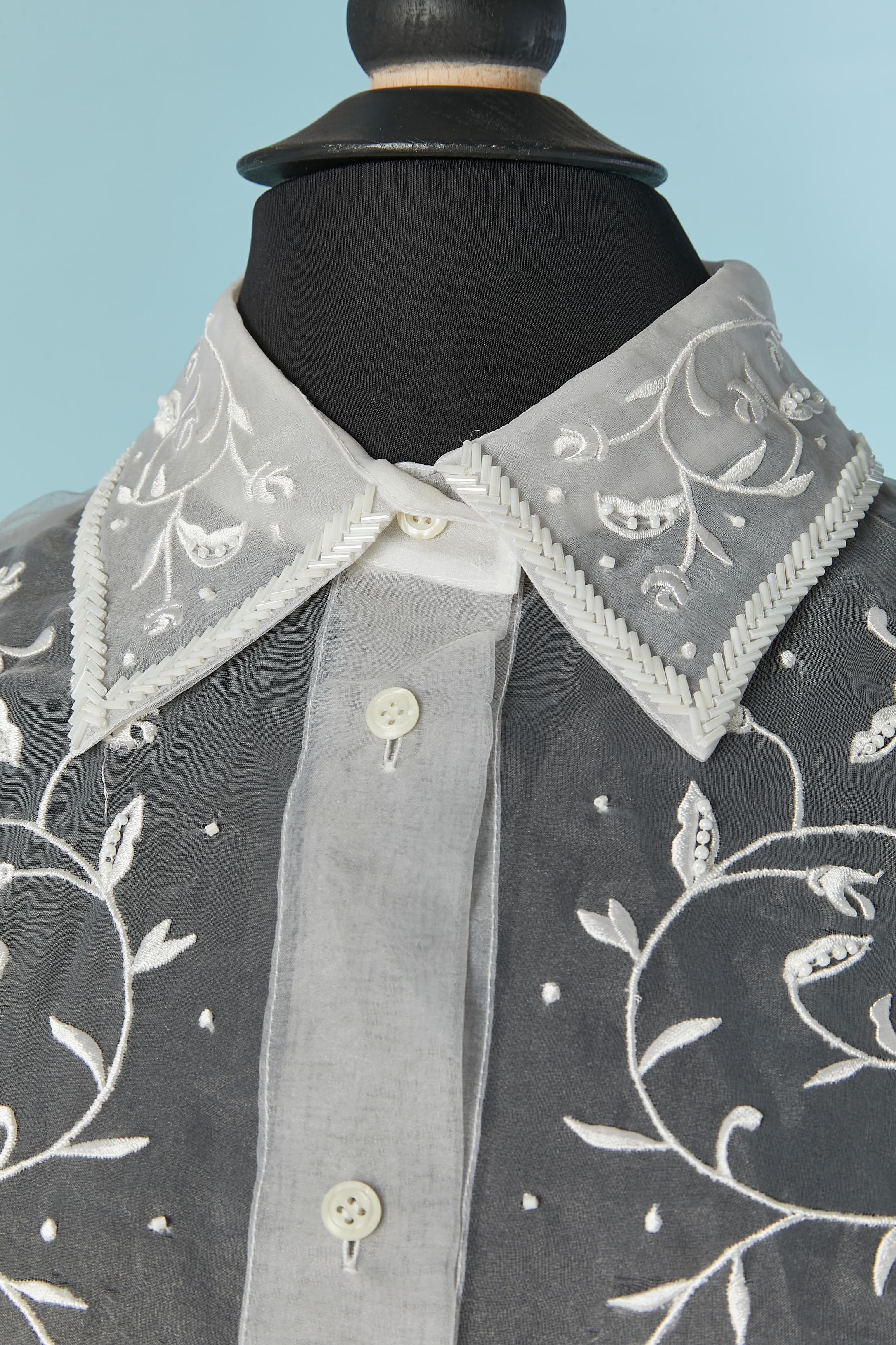 Camicia in seta trasparente con ricami in filo e perline. Chiusura con bottoni e asole al centro del davanti. Gancio e occhiello sui polsini. 
TAGLIA 46 (IT) 10 (US) 