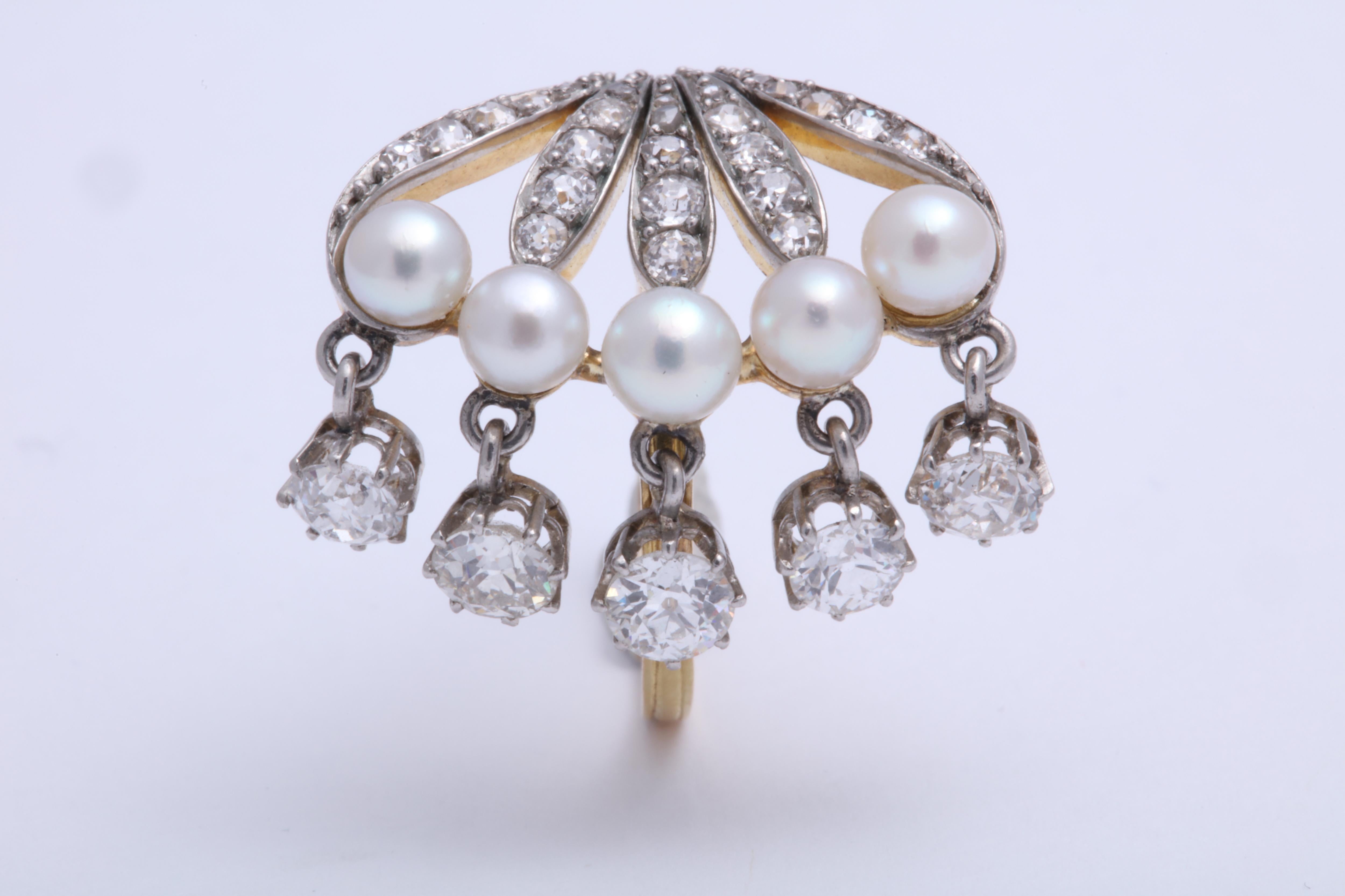 A beautiful and fun Edwardian ring- it looks great on! 5 seed pearls with approximately 1.35 total carats of diamonds both set into the mount and dangling. The ring is platinum on 18K. 