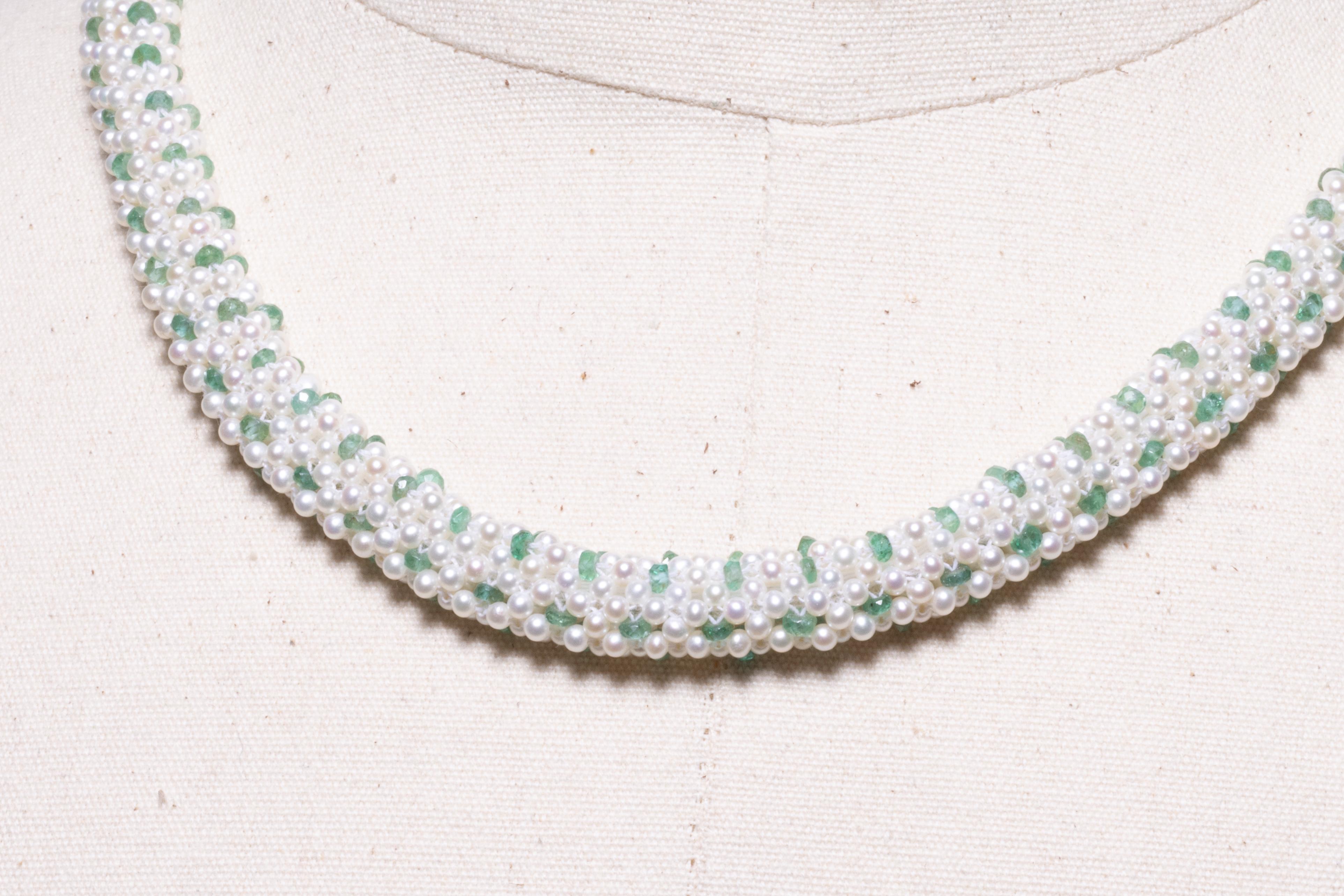 This is an intricately woven necklace of seed pearls and faceted emeralds.  Very unusual with very fine, detailed craftsmanship.  It has an 18K gold clasp with an extra inch of chain to adjust the length between 19 and 20 inches.  The shape is flat