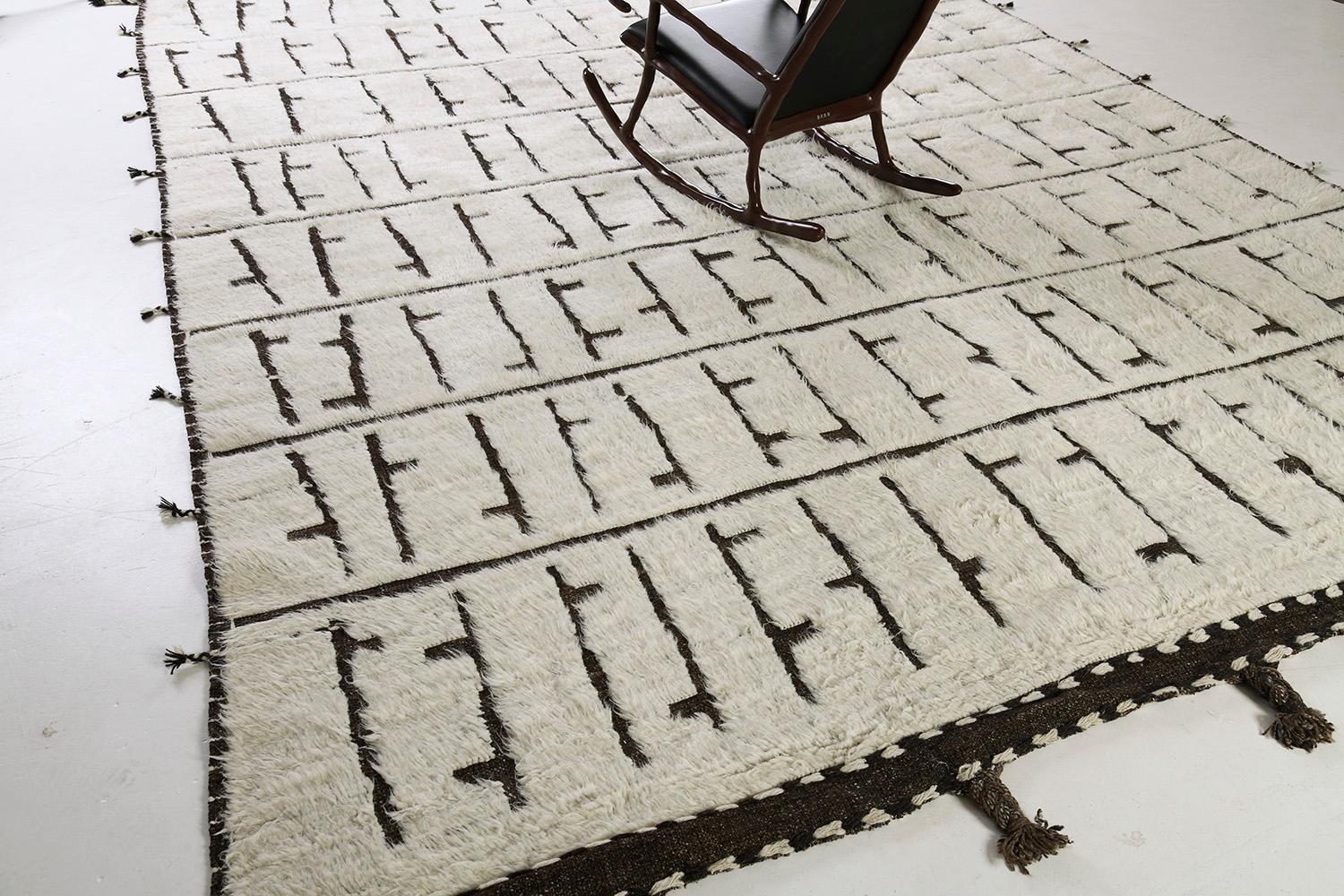 The Segge rug is a handwoven wool piece that features design elements that complements the modern design world. The repetitive brown symbolic elements create balance and harmony, handwoven with a natural brown pile weave in an ivory field. This