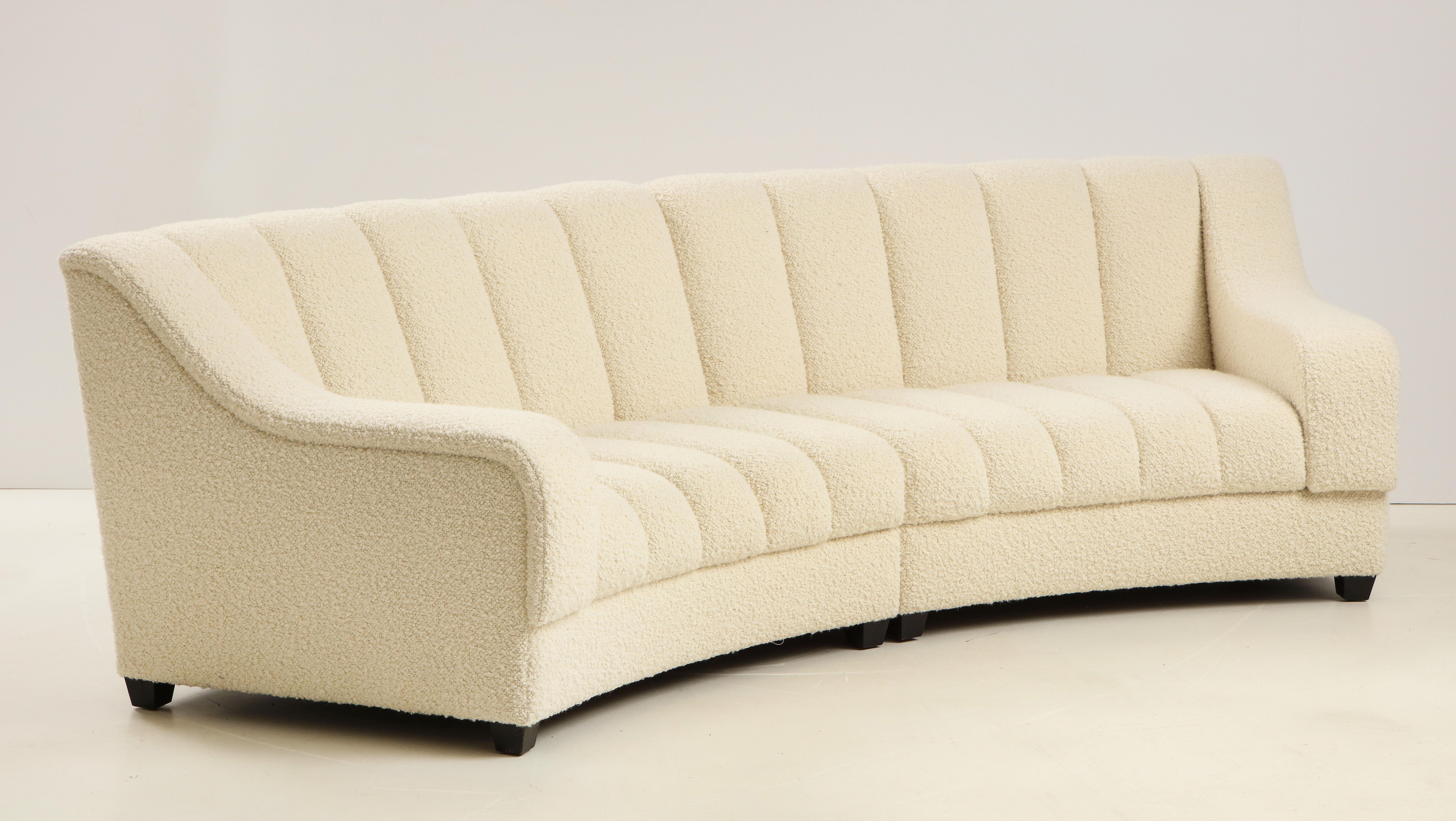 This curved sofa in Pierre Frey ivory boucle was newly handcrafted by master craftsmen in Florence, Italy. It consists of 2 modular sections which come together to form one unit. Segmented seat style inspired by De Sede design. Upholstered in french