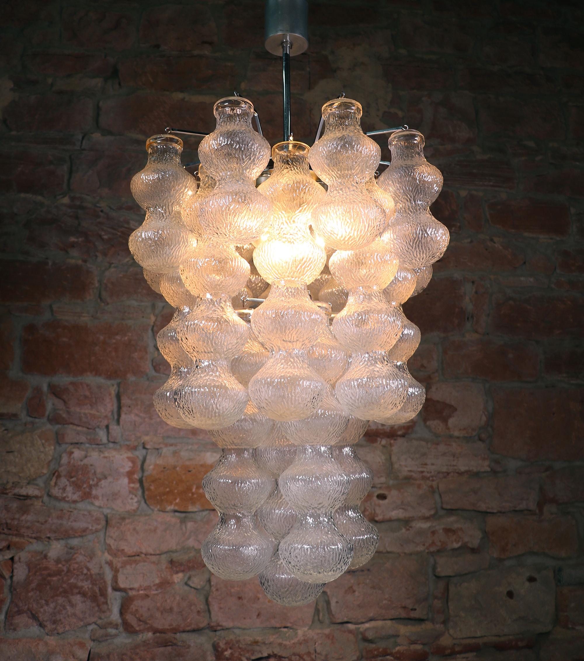 Elegant large multi layered chandelier with handblown textured Murano bubble glass tubes hanging from a chromed spider suspension. Chandelier illuminates beautifully and offers a lot of light. Gem from the time. With this light you make a clear