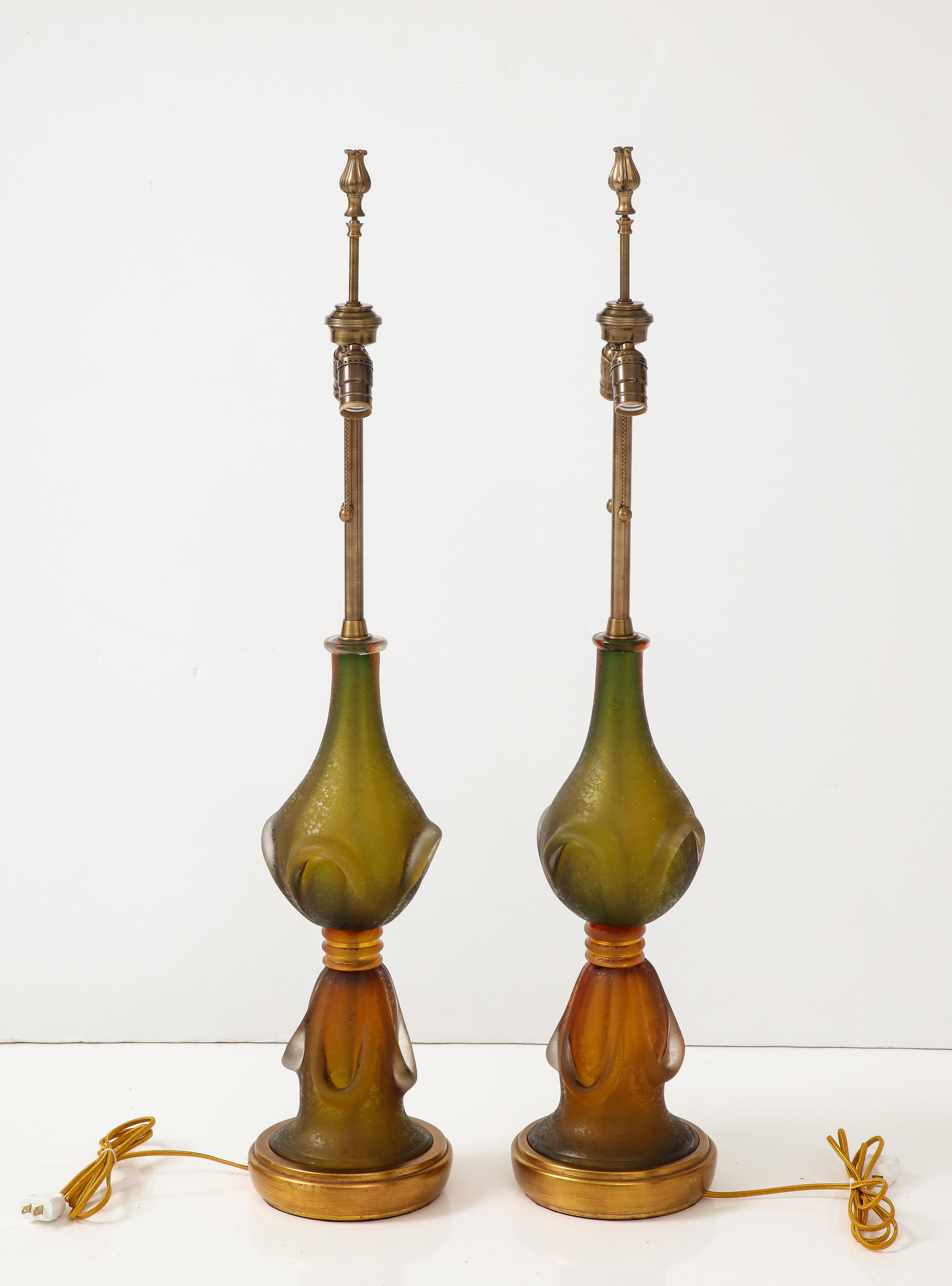Pair of Mid Century Murano glass statement lamps by Seguso featuring a moss green/amber color and  corroso/matte finish. Lamps have been rewired for use in the USA. 75W max bulbs.