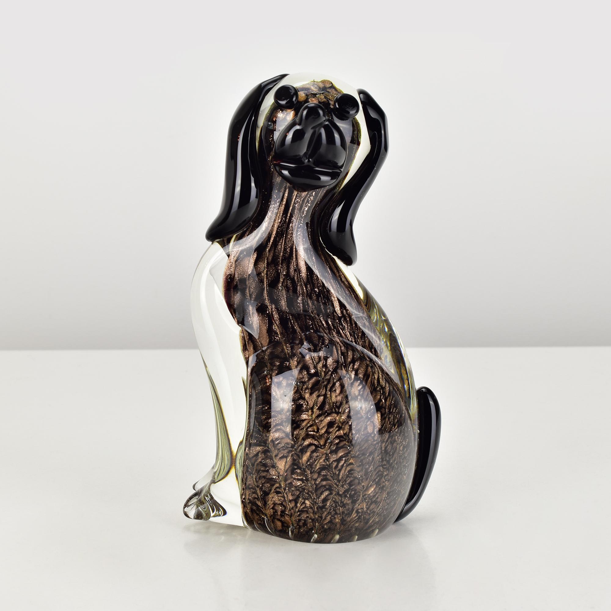 Esta figura de perro de aventurina de 16 cm de alto con inclusiones de polvo de oro rosa de Seguso está hábilmente hecha a mano y tiene una forma alargada y grácil, con orejas, ojos, nariz y cola negros
Un bello objeto de coleccionista y muy