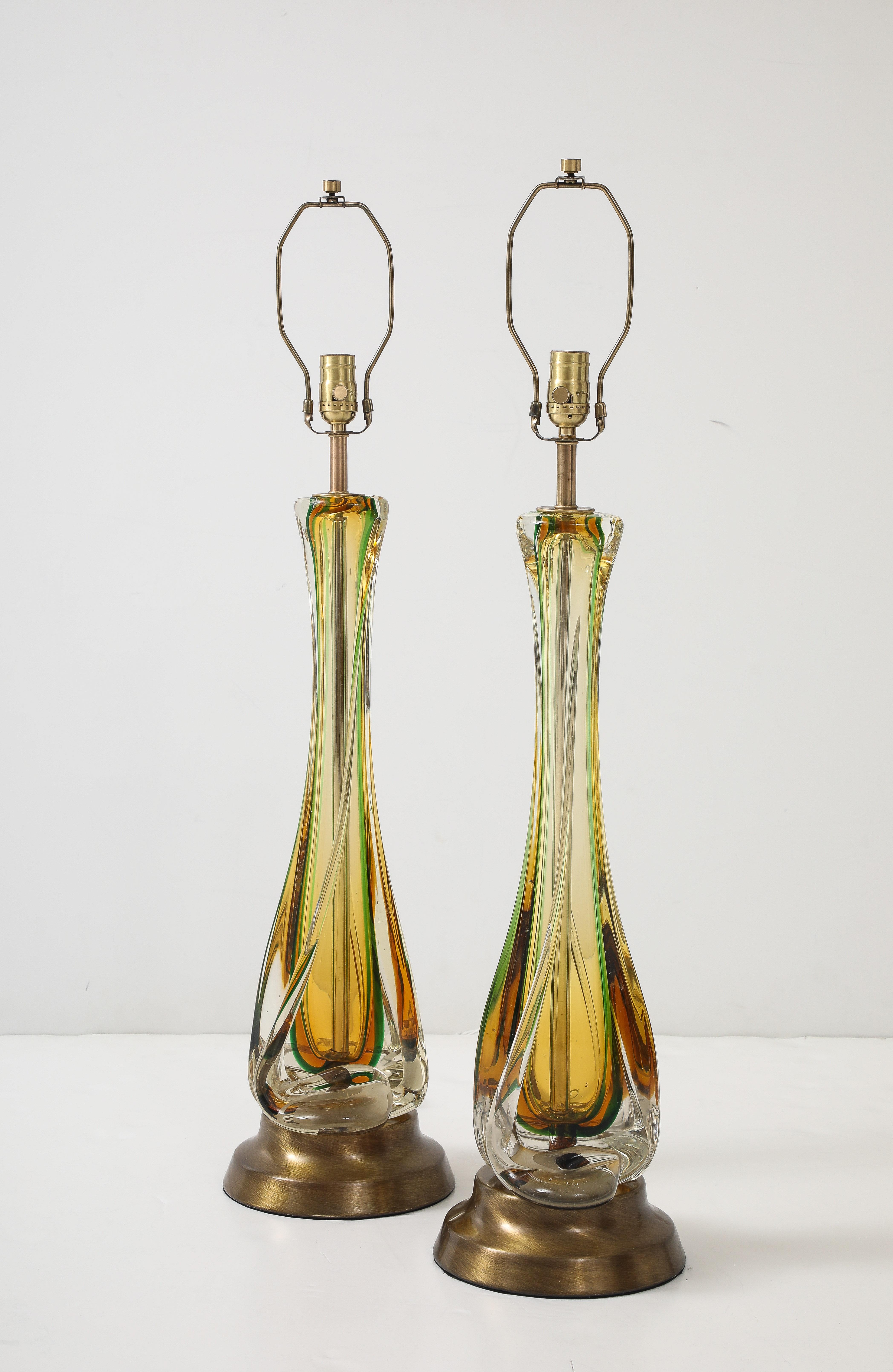 Ein Paar Murano-Glaslampen aus der Mitte des Jahrhunderts mit einer Farbkombination aus Smaragdgrün und Bernstein, umhüllt von einem klaren Glasüberzug. Die Lampen haben neue Bronzesockel und -fassungen. Professionell neu verkabelt für den Einsatz