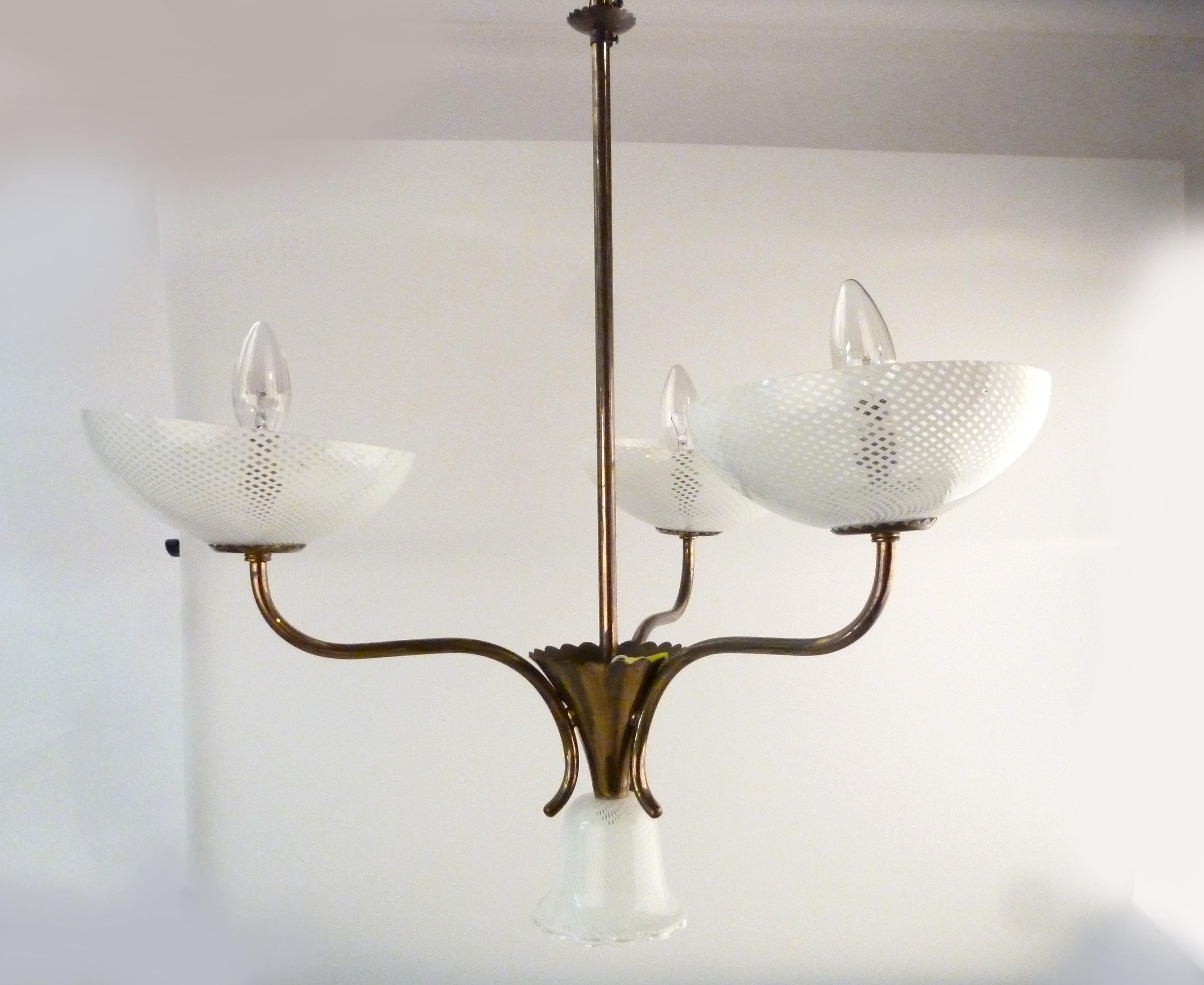 1950s Italian Seguso brass and Murano filigreed glass three-arm pendant light.
Wired for the U.S. and uses three 25 W-max European bulbs. Chain not included.