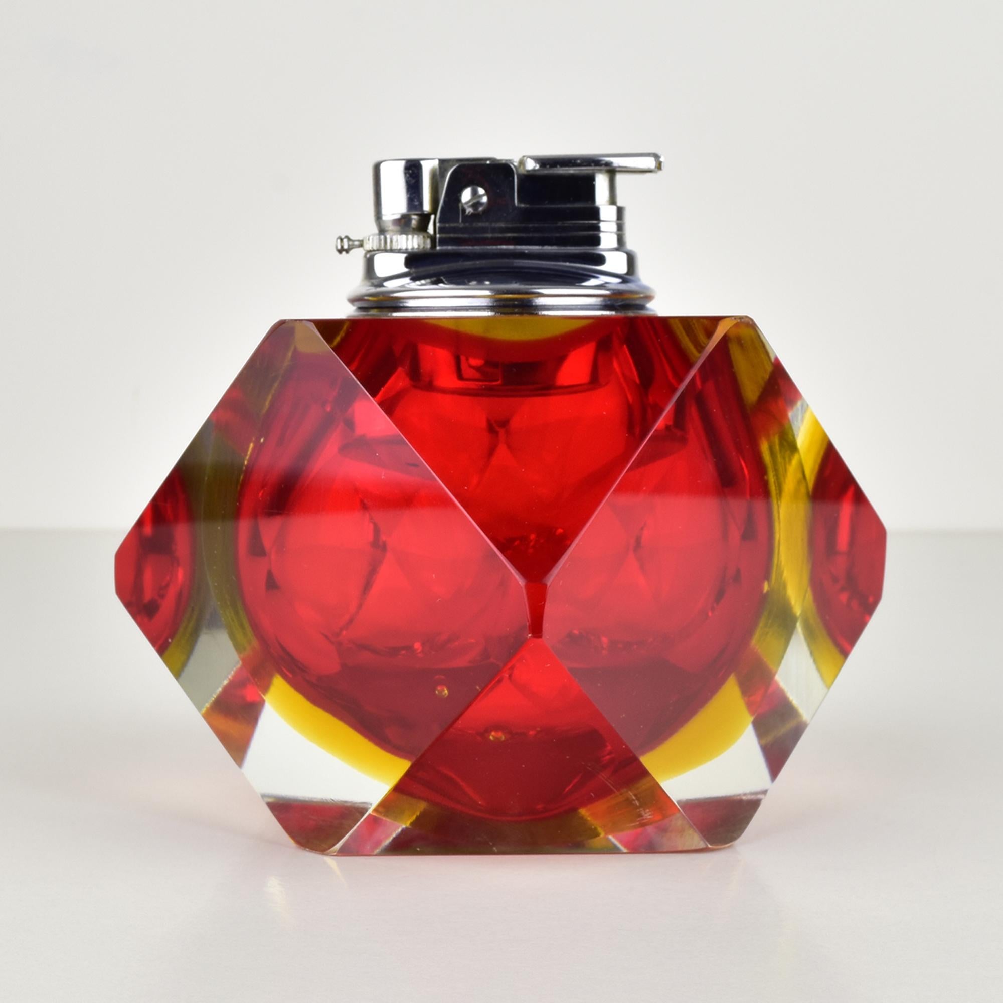 Ce briquet de table conçu par Flavio Poli à partir de la série Sommerso pour Seguso est un exemple remarquable du design moderne du milieu du siècle dernier. Il présente des teintes rouges et jaunes vibrantes, mettant en valeur la technique unique
