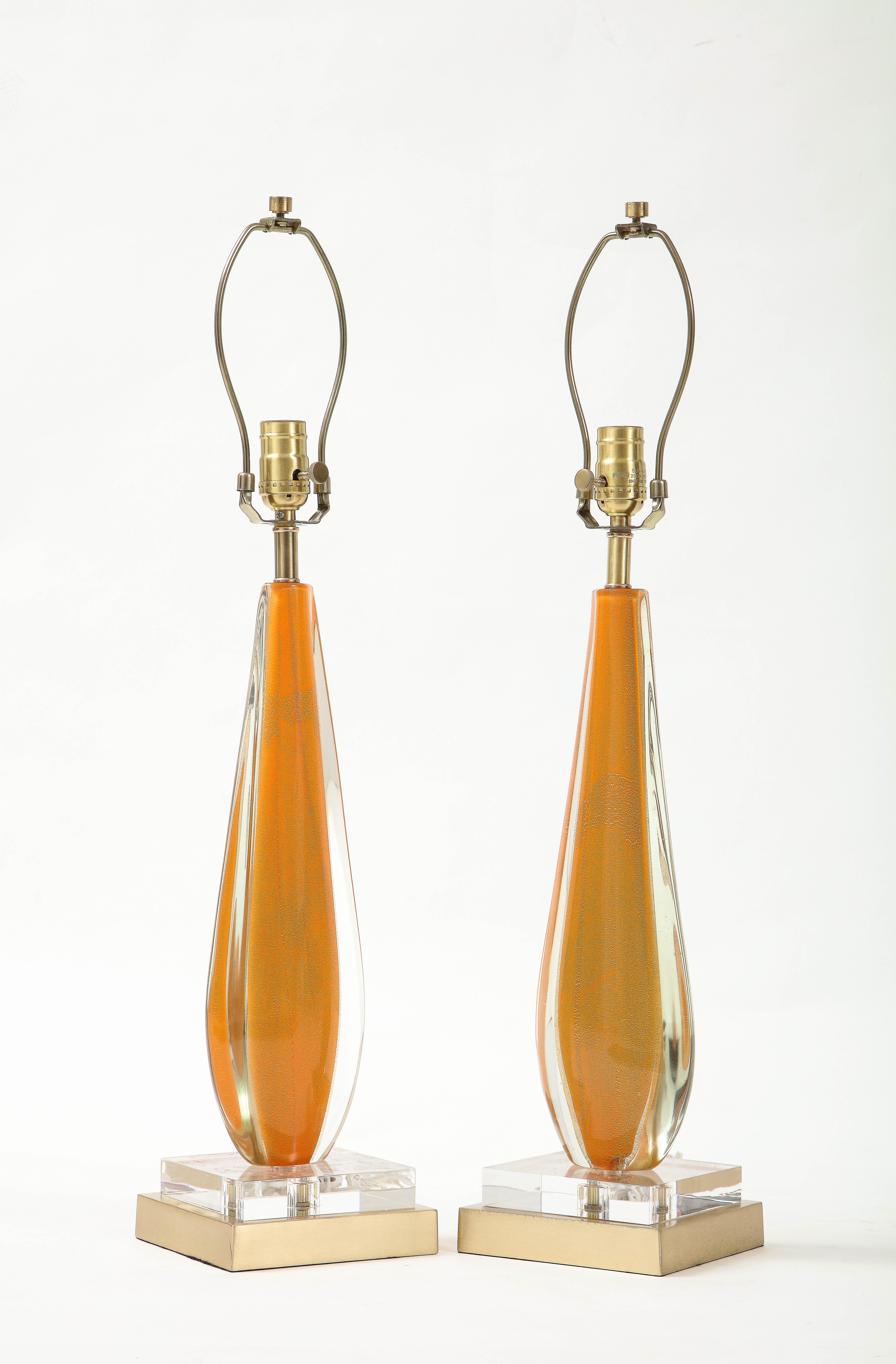 Pair of Melon colored murano glass lamps in an elongated tear drop shape resting on custom lucite and brushed brass square bases. Rewired for use in the USA, 100W max.