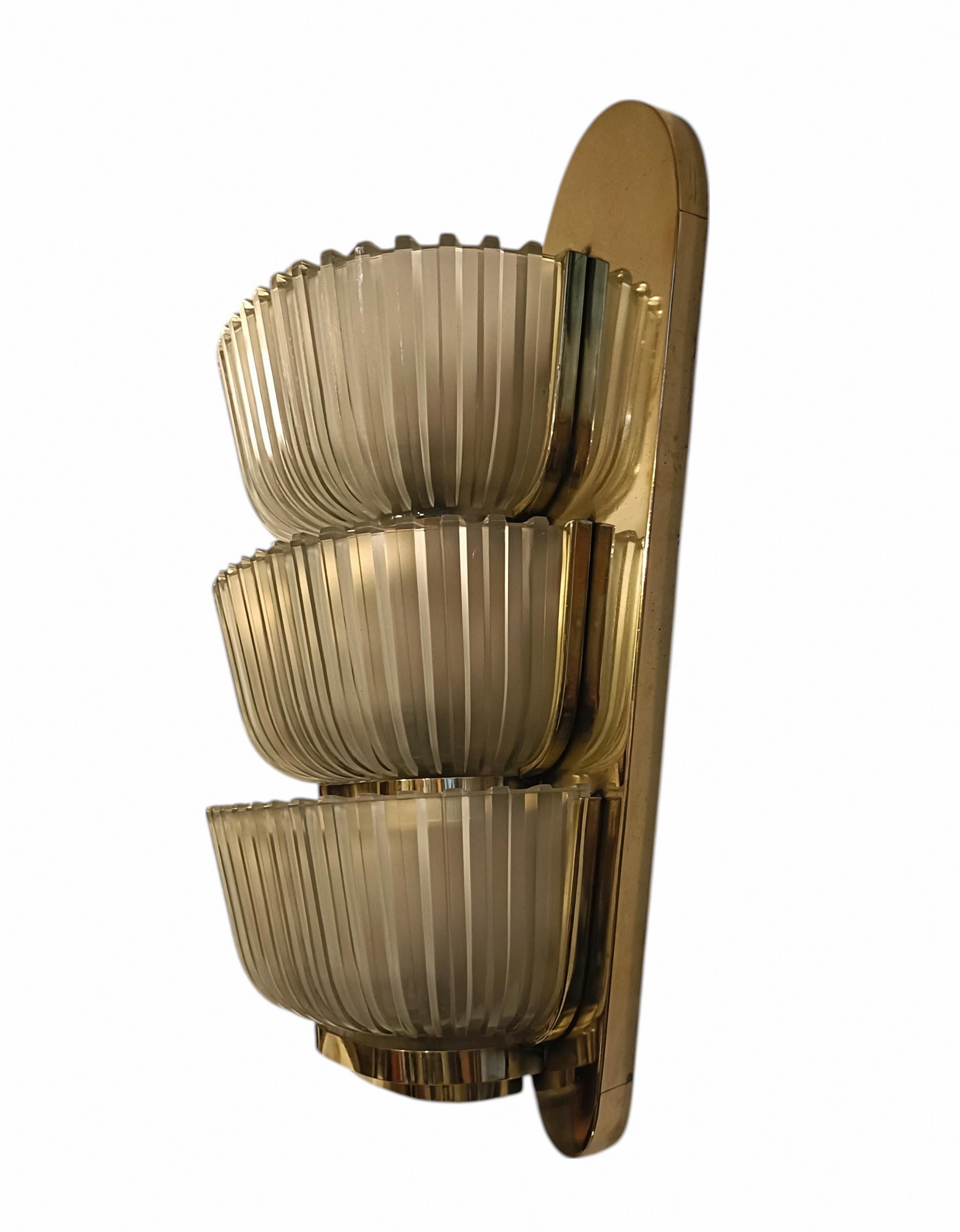 Rarissima lampada da parete di Archimede Seguso, interamente in ottone e diffusori a conchiglia in vetro di Murano. Italia 1930.
L'articolo nonostante l'eta', si presenta in buone condizioni conservative, presenta soltanto lievi  segni del tempo.